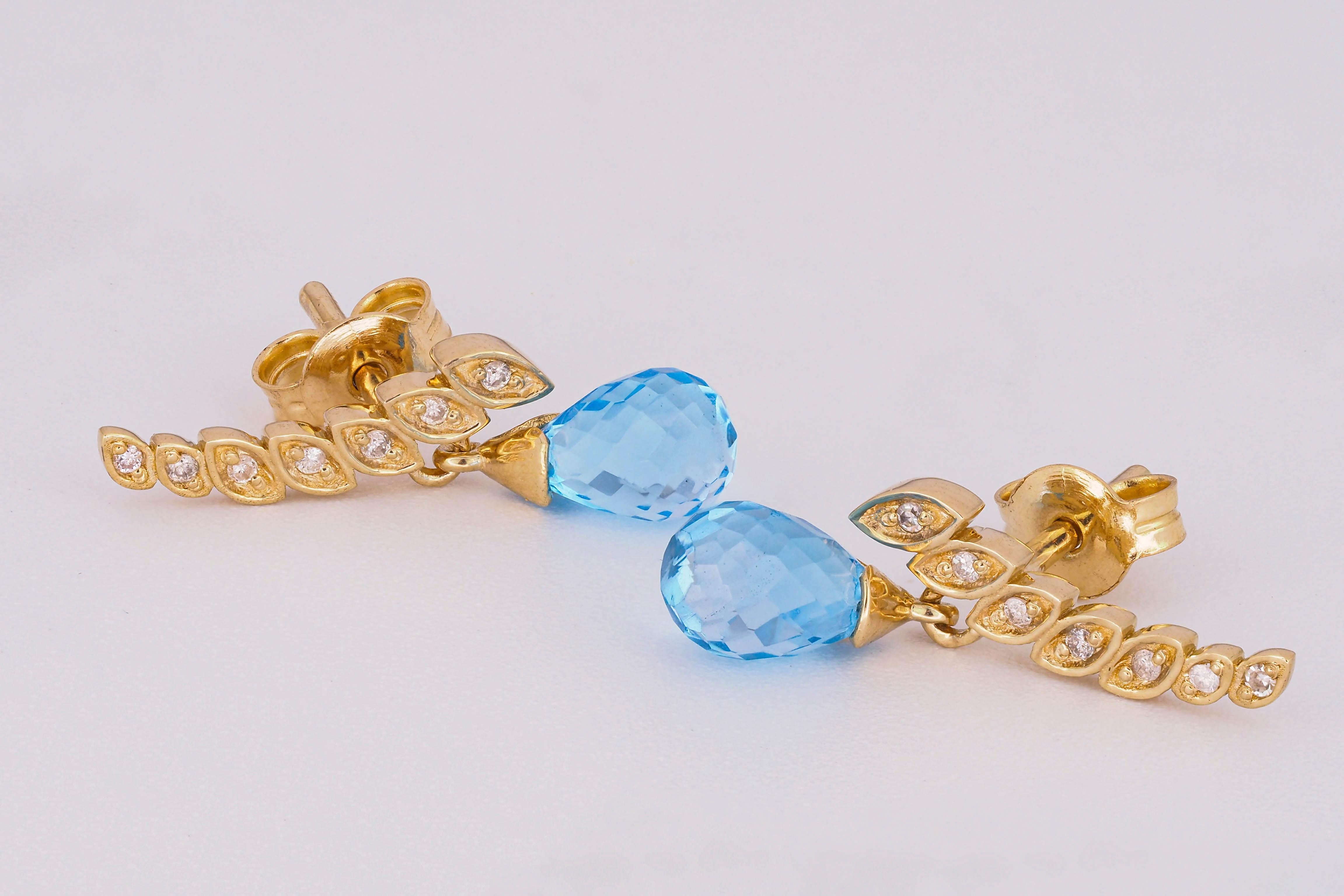 14 kt solid gold earrings with natural topazes briolettes and diamonds. November birthstone.
Total weight: 2.70 g.
Size: 16 x 10 mm.

Central stones: Natural topaz - 2 pieces
Cut: Briolettes
Weight: approx 2.10 ct total.
Color: Blue
Clarity: