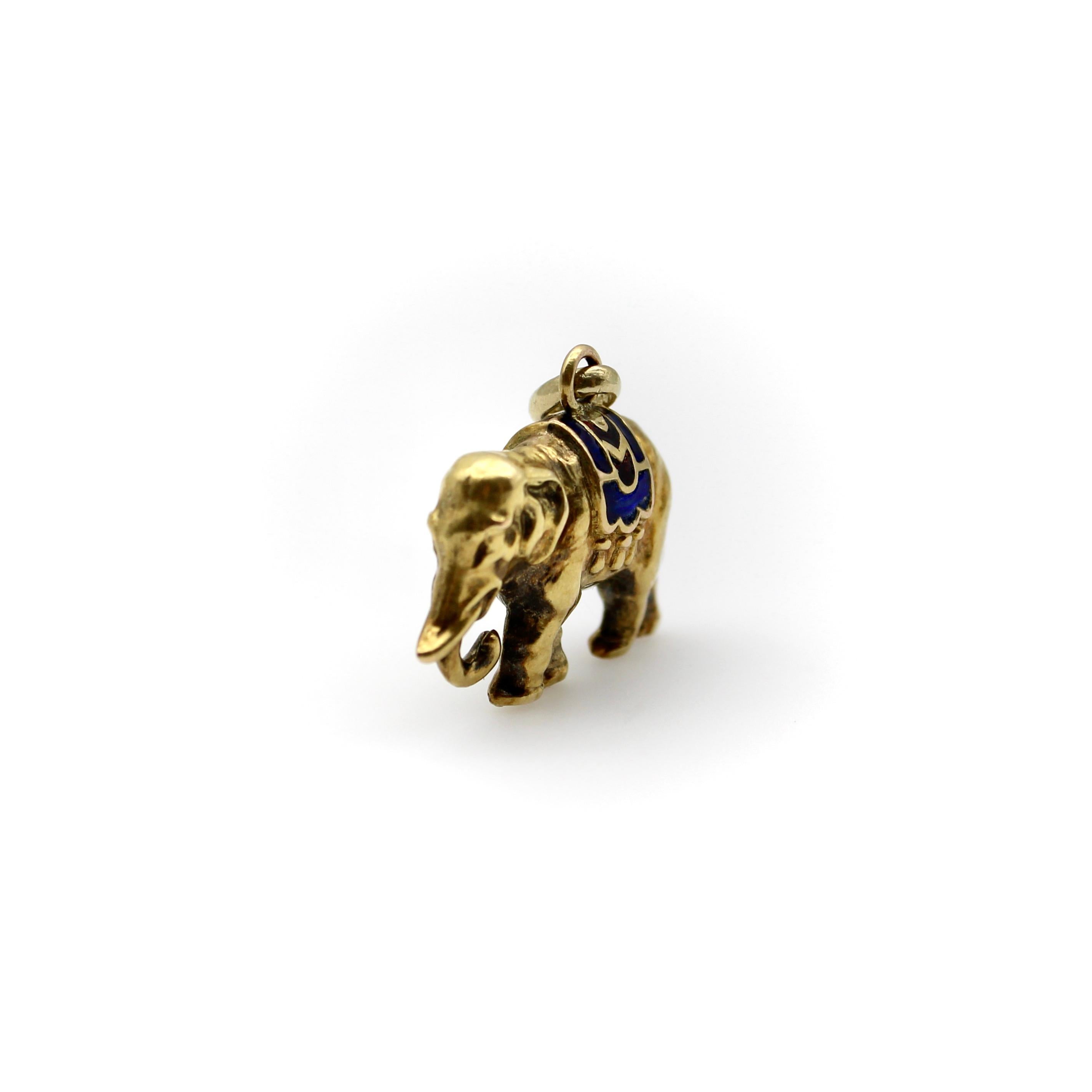 Circa the Edwardian era, this 14k gold elephant charm is beautifully detailed. It has an emotive face and a lovely patina from its age that gives the charm shading and depth. The elephant wears a pretty enamel saddle with red, royal blue, and teal