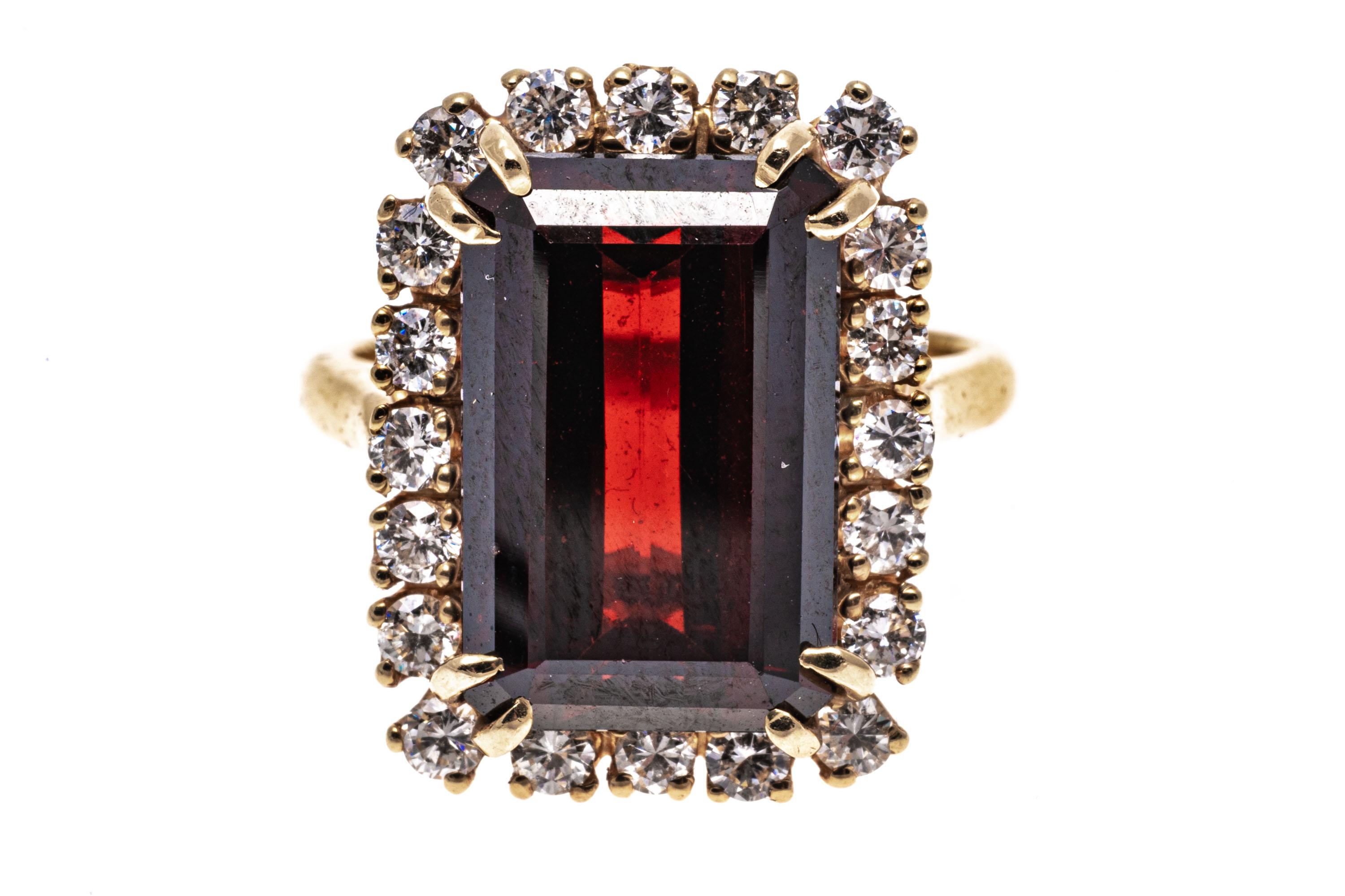14k yellow gold ring. !4k yellow gold beautiful elongated, emerald cut faceted, medium to dark color burgundy garnet, approximately 7.43 CTS, set with split prongs and decorated with a halo of round faceted diamonds, approximately 0.60 TCW, prong