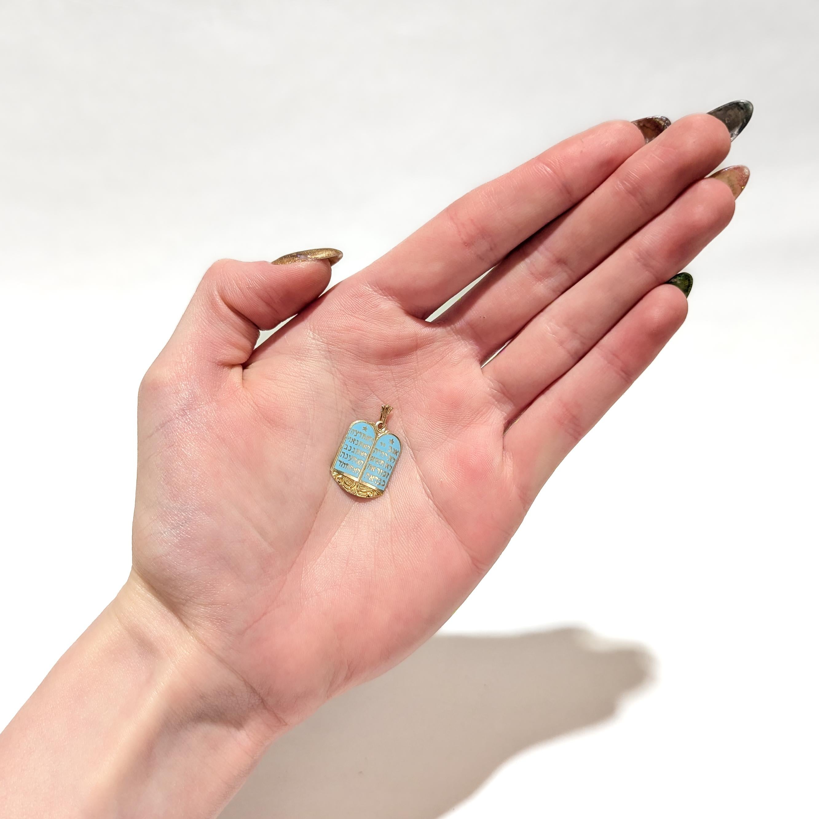 Pendentif (ou breloque pour un bracelet) en or et émail de style figuratif.

En or jaune 14 carats avec émail de couleur turquoise.

Sous la forme des Tables de la Loi - les tablettes de pierre sur lesquelles Dieu a inscrit les dix commandements