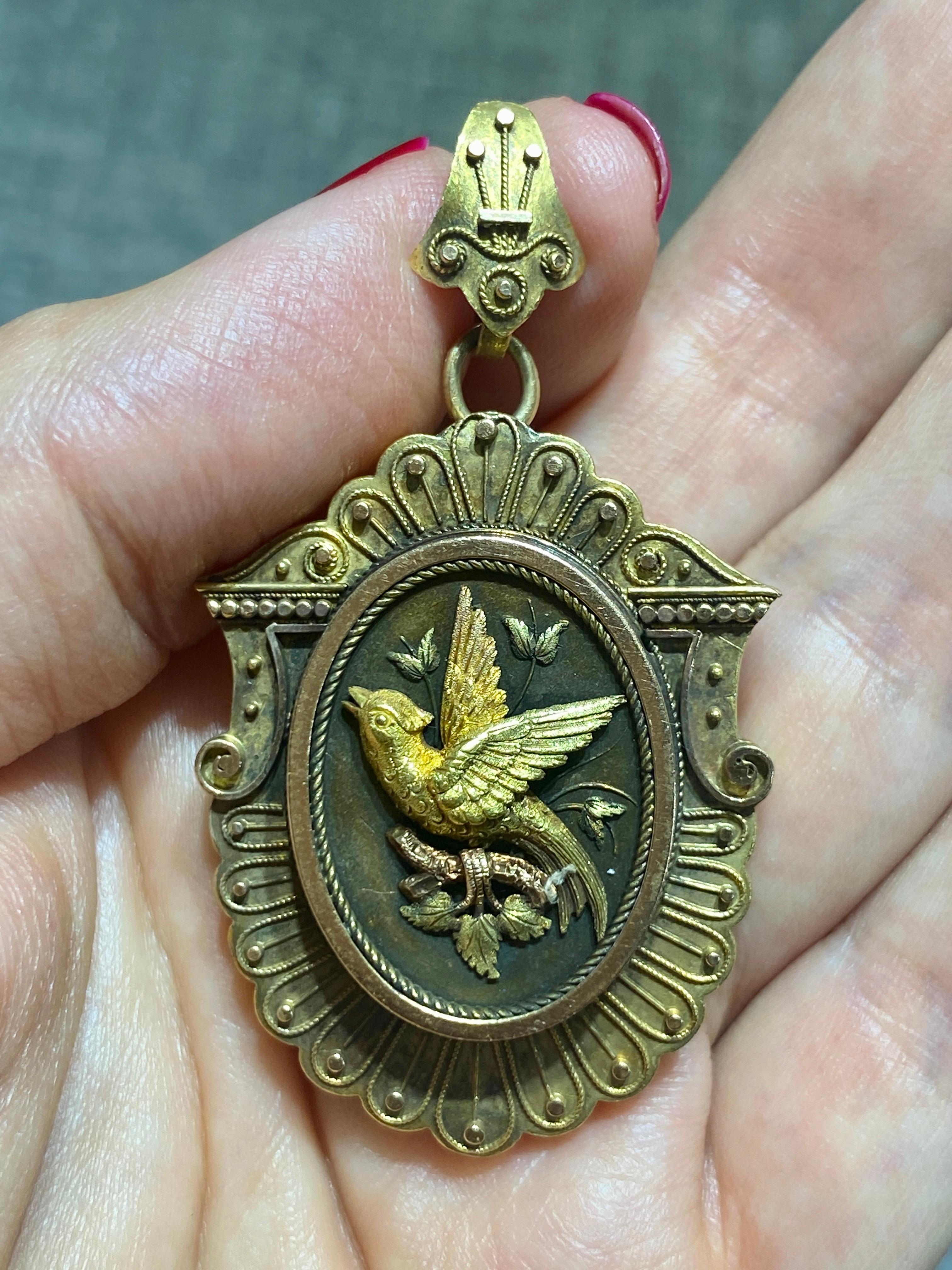 Questo affascinante ciondolo in oro 14k degli anni '30 è ornato da un delicato disegno di uccelli. Ha un piccolo medaglione sul retro per contenere una ciocca di capelli o un tesoro simile.