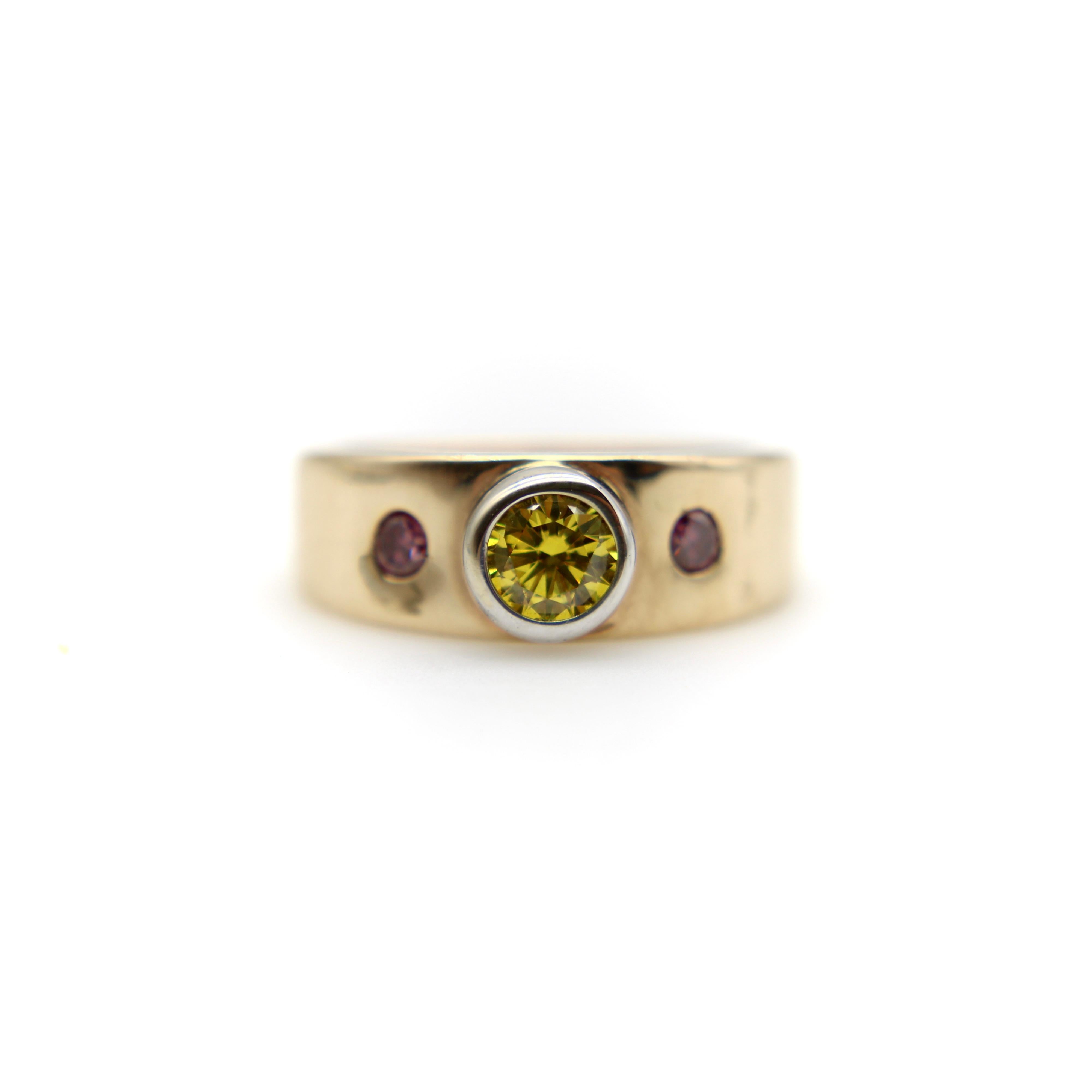 This 14k gold ring was created by MWM Goldsmithing—a Portland, Oregon jeweler known for intricate designs and one-of-a-kind custom pieces. The ring features three natural diamonds, irradiated to achieve stunning pink and yellow hues. The central