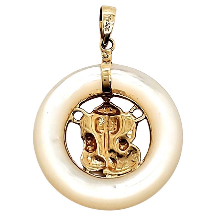 Questo affascinante ciondolo raffigura la venerata divinità indiana Rever in oro 14 carati, circondata da una delicata madreperla. 

Senti la morbidezza della conchiglia contro i tuoi polpastrelli mentre ammiri gli intricati dettagli del ciondolo,