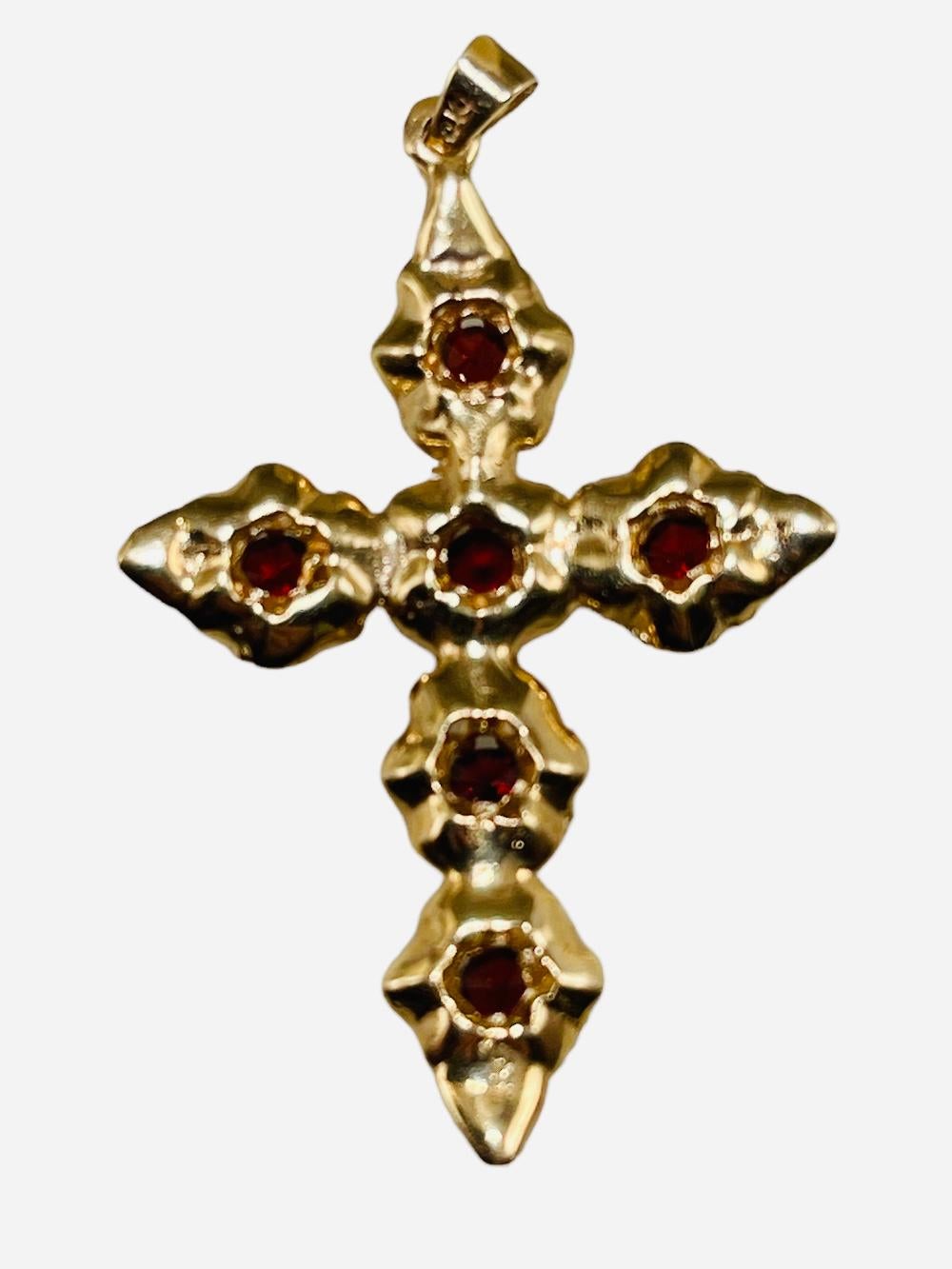 This is a 14K yellow gold and garnet Roses flower cross pendant. This cross pendant has six round cut faceted garnets that embellish the roses that adorn the cross. They are mounted in 14K gold prong setting. 