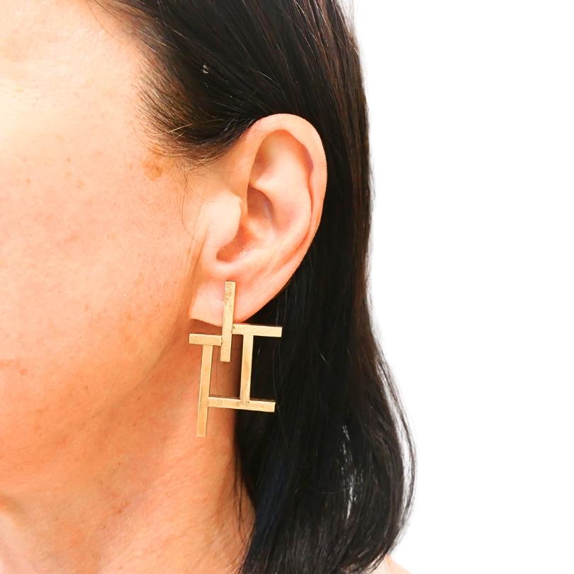 Estos pendientes de oro de 14k presentan un inusual diseño geométrico. Las líneas entrecruzadas y los cuadrados crean un aspecto audaz y estructurado. Las formas de marco abierto dan a los pendientes una sensación de ligereza. u2028El diseño de los