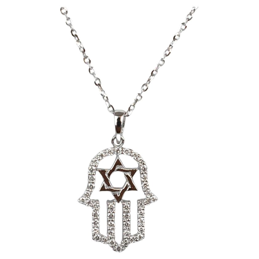 El Colgante Mano Hamsa Pequeña está hecho de oro macizo de 14 quilates.
Disponible en tres colores de oro, Oro Blanco / Oro Rosa / Oro Amarillo.

Este collar está adornado con diamantes blancos naturales de talla redonda engastados en pavé. Perfecta