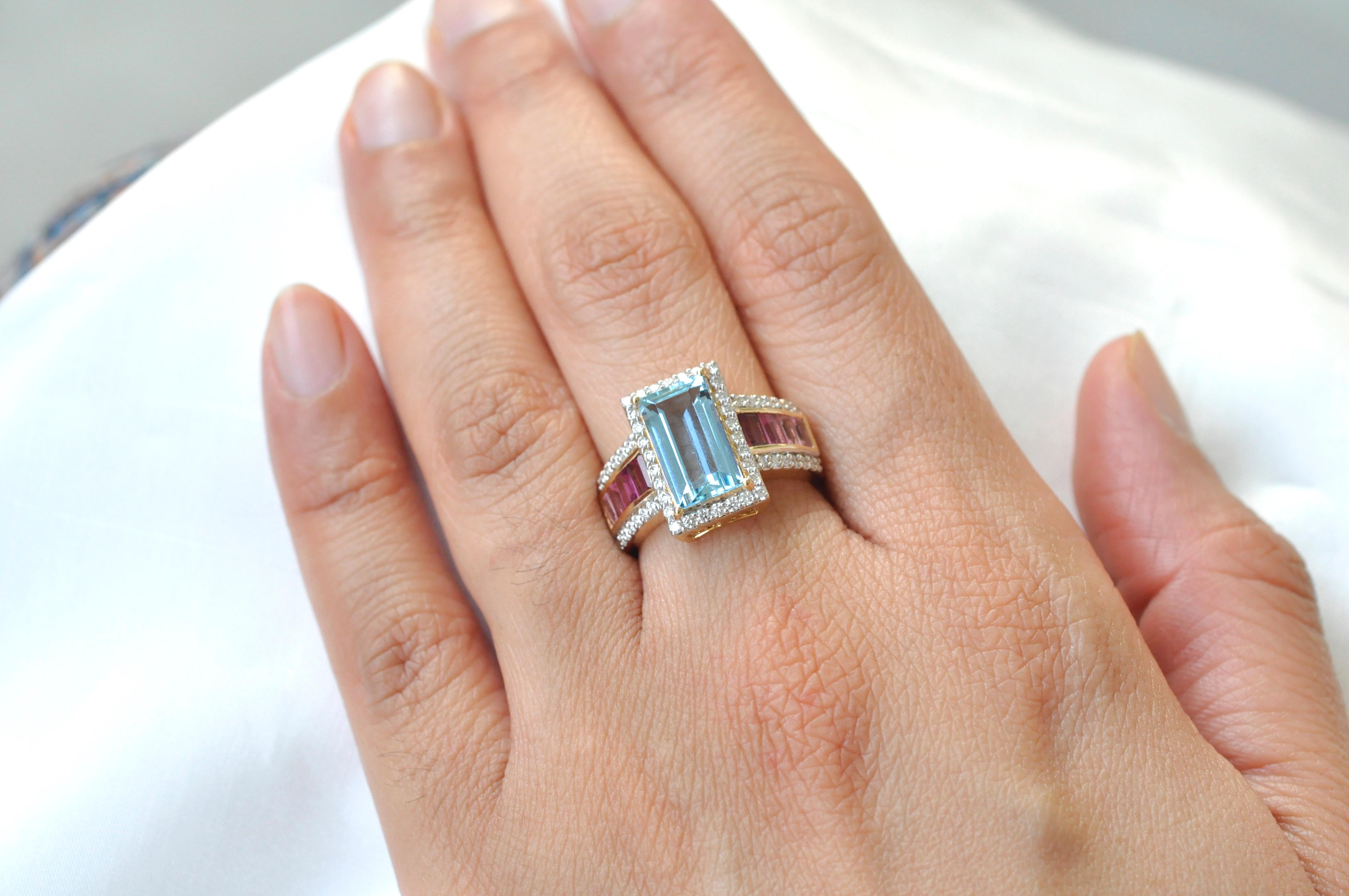 14 karat gold aquamarine pink tourmaline baguette engagement diamond ring.

This extraordinary ocean blue aqua-marine and pink tourmaline ring is dreamy and encapsulating. The center exquisite pastel aquamarine solitaire baguette cut measuring 12 x