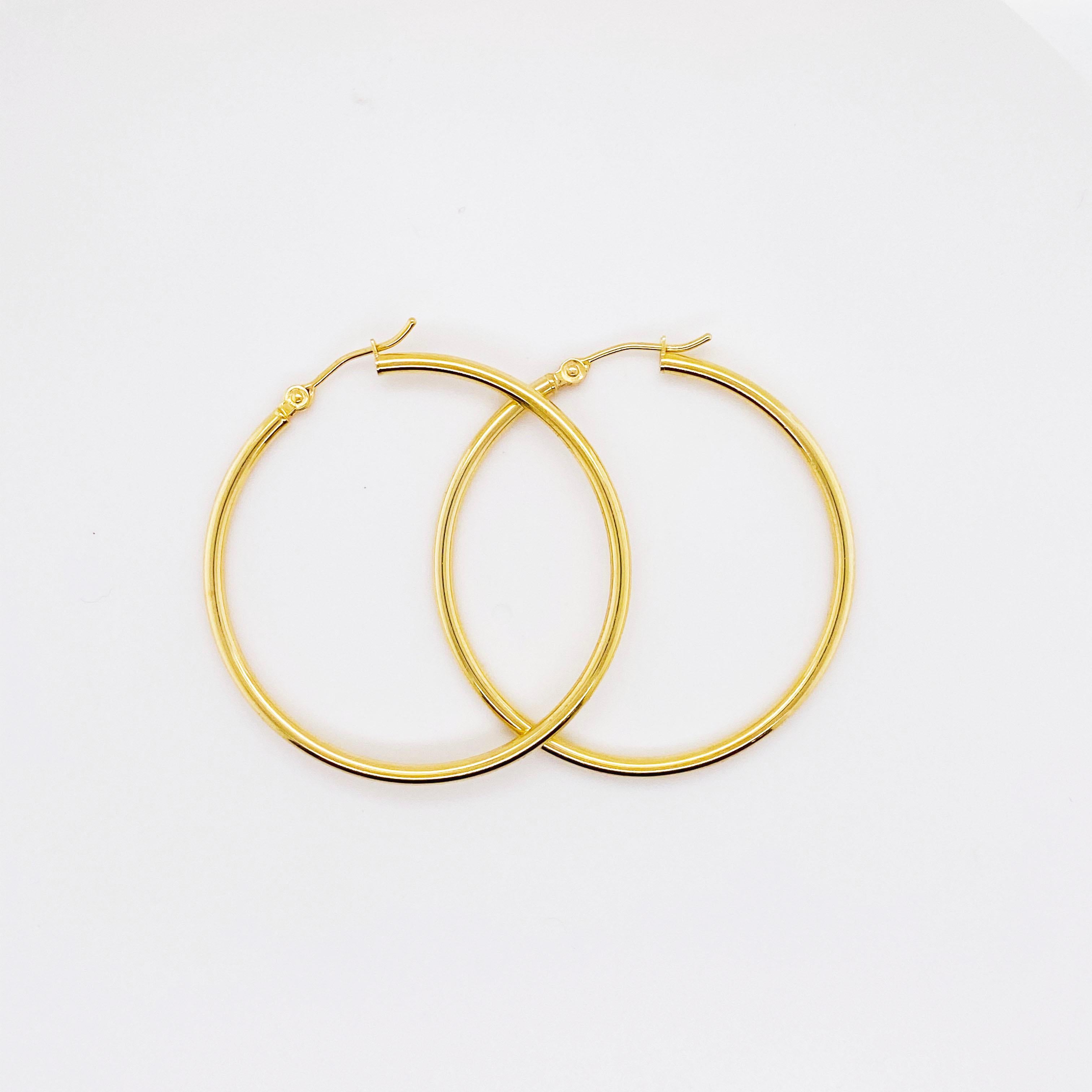 The 14 karat yellow gold hoops are hollow to keep them light on your ears.  They have a handy hinged post so that you never have to worry about an earring back.  The back is already there!
The gold part of the earring is 2 millimeters wide and it is