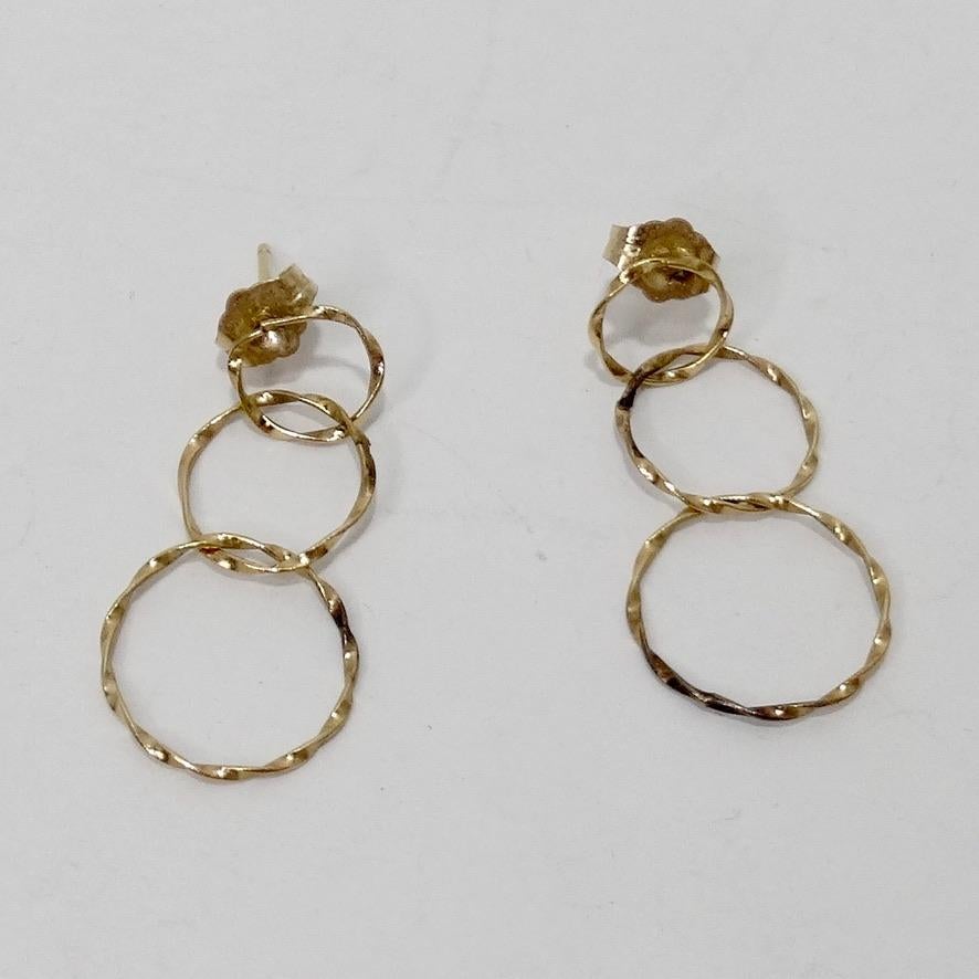 Timeless and chic 14k gold dangle earrings. The earrings feature three circles stacked on top of one another in a beautiful textured gold metal. Balance them out with your gold Cartier love rings or create a contrast by styling them with your