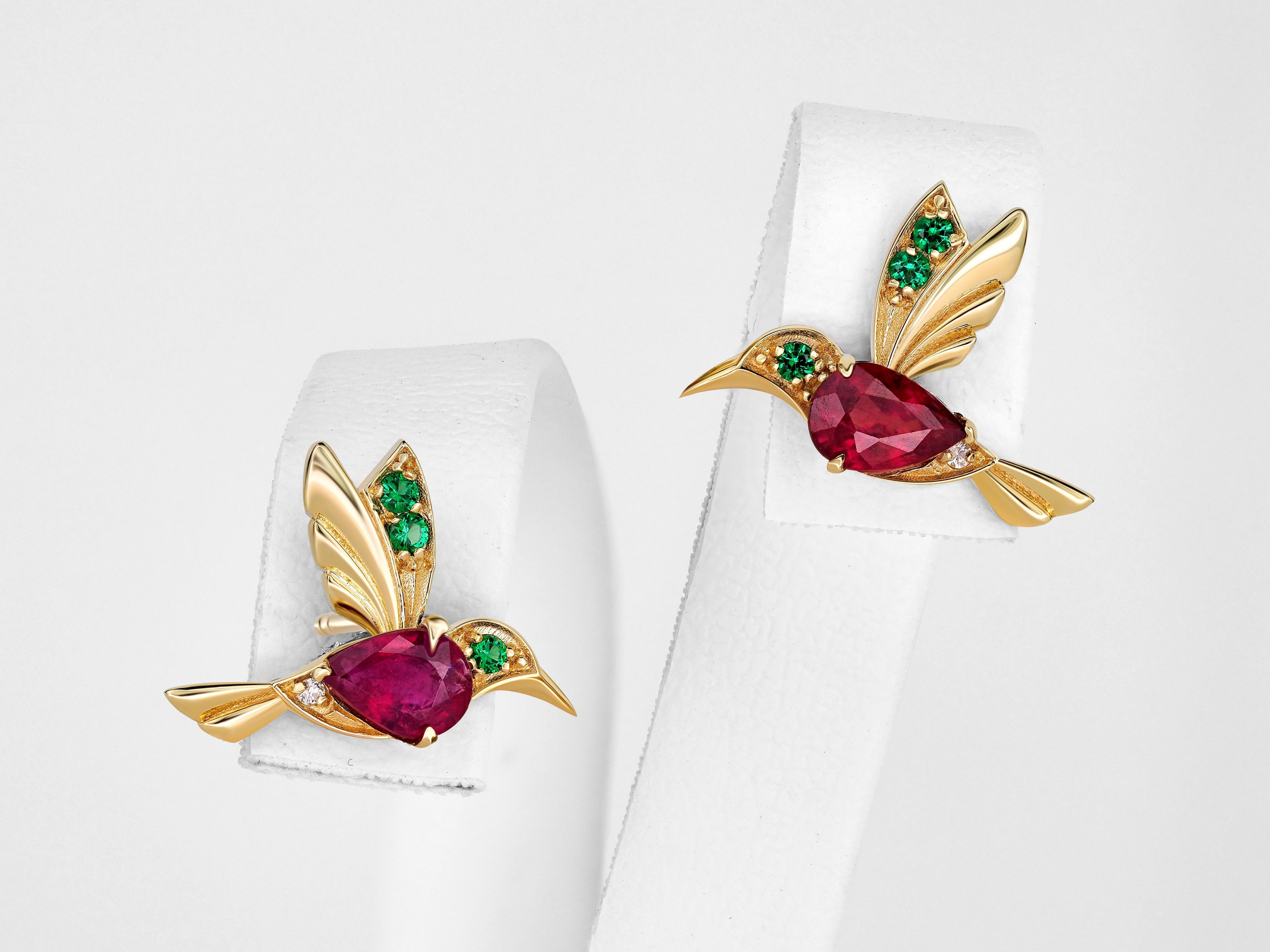 Orecchini a perno con colibrì e gemma colorata. 

 Metallo: oro 14 carati
Peso: 1,95 g.
Dimensioni: 11,73 x 15,85 mm.
Pietre centrali: Rubini autentici
Tagliare:  pera
Peso: circa 1 ct. può essere più o meno grande.
Colore: il rosso può essere
