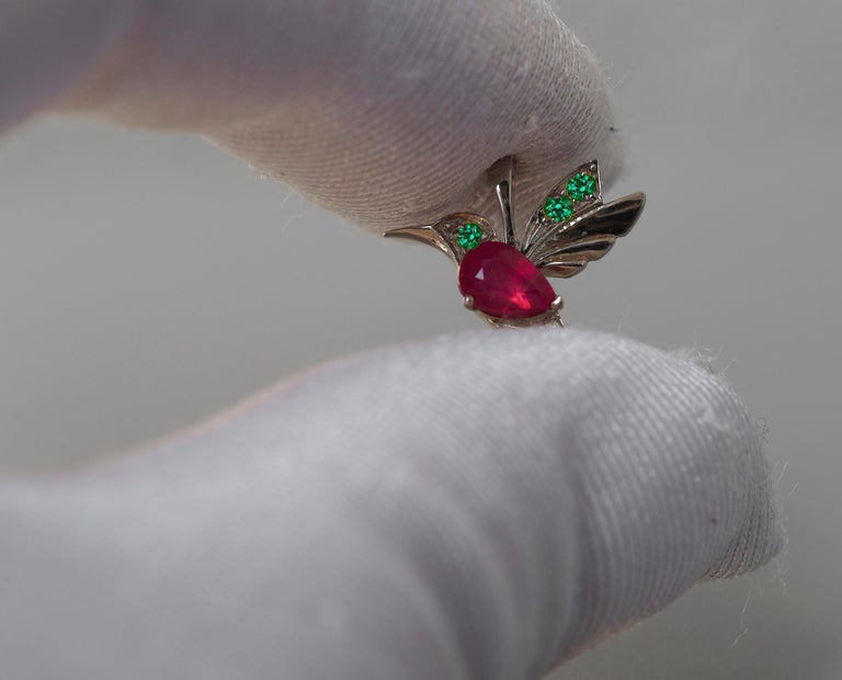 14k Gold Hummingbird Pendant with Rubies. Bird  Pendant with colored gemstones.
14 kt gold bird pendant with ruby, tsavorites and diamond.

Weight: 0.9 g.
Size: 12x16.6mm
Set with ruby, color - red
pear cut, 0.7 ct. in total (6x4 mm size)
Clarity: