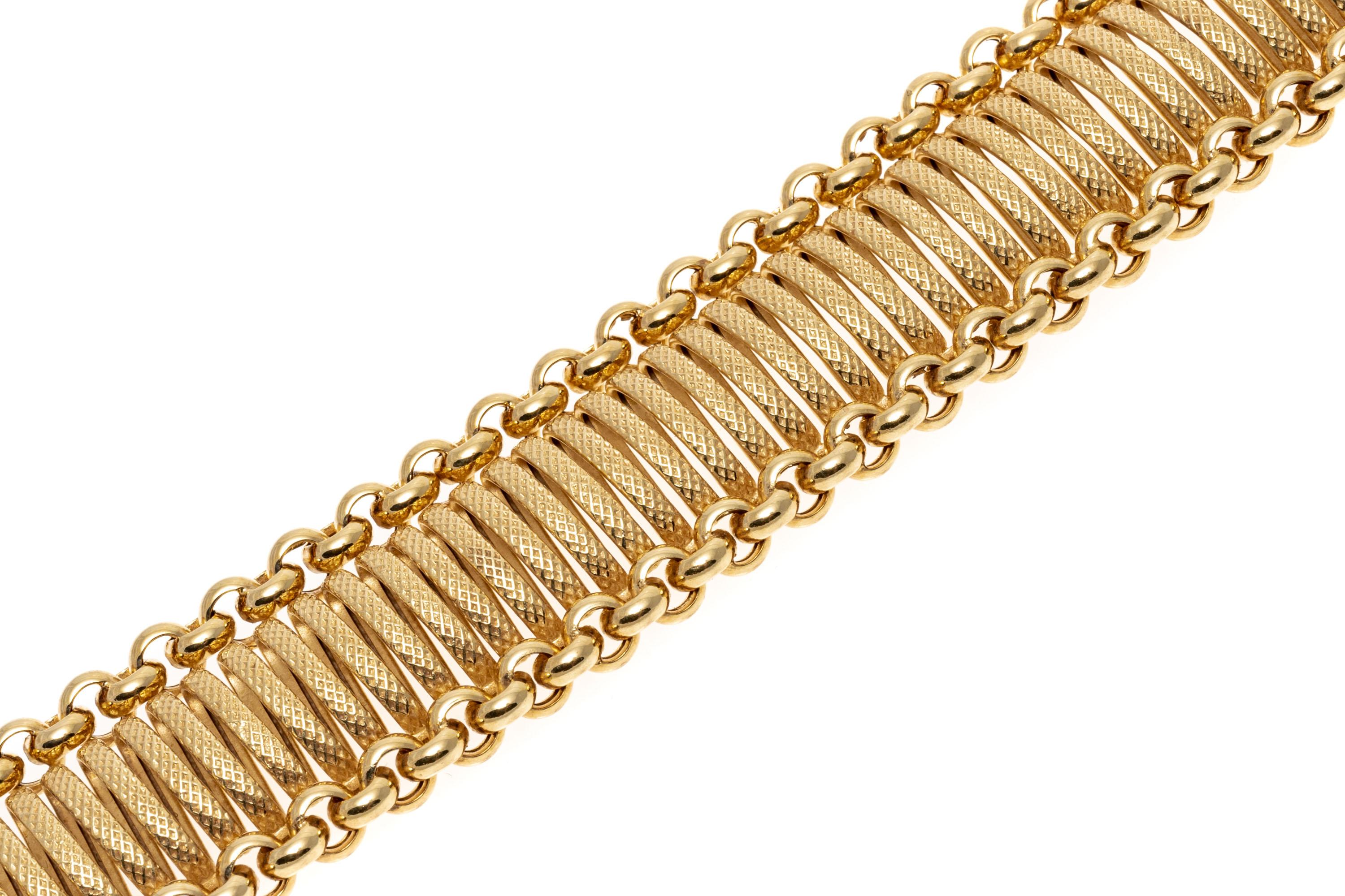 A unique 14K yellow gold bracelet. A diamond cut thread runs through the center of the bracelet in a serpentine design. Trimming the edges of the bracelet are round links style chains with a bright polished finish. Hidden box style clasp with safety