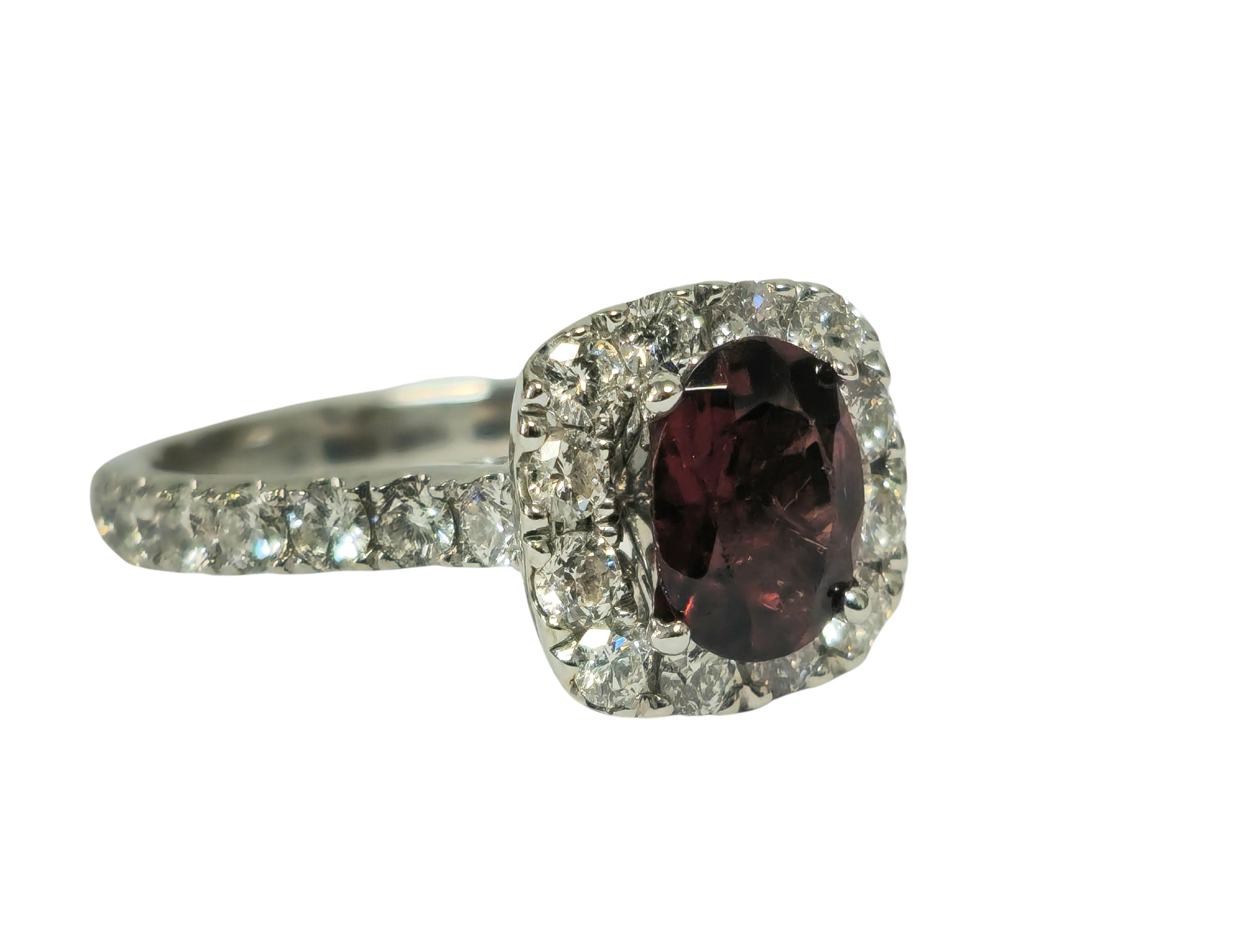 Fashioned from stunning 14k white gold, this ring boasts a total of 1.20 carats of dazzling round brilliant-cut diamonds, characterized by VS-SI clarity and G color. The focal point features a mesmerizing oval-shaped garnet, securely set in prongs,