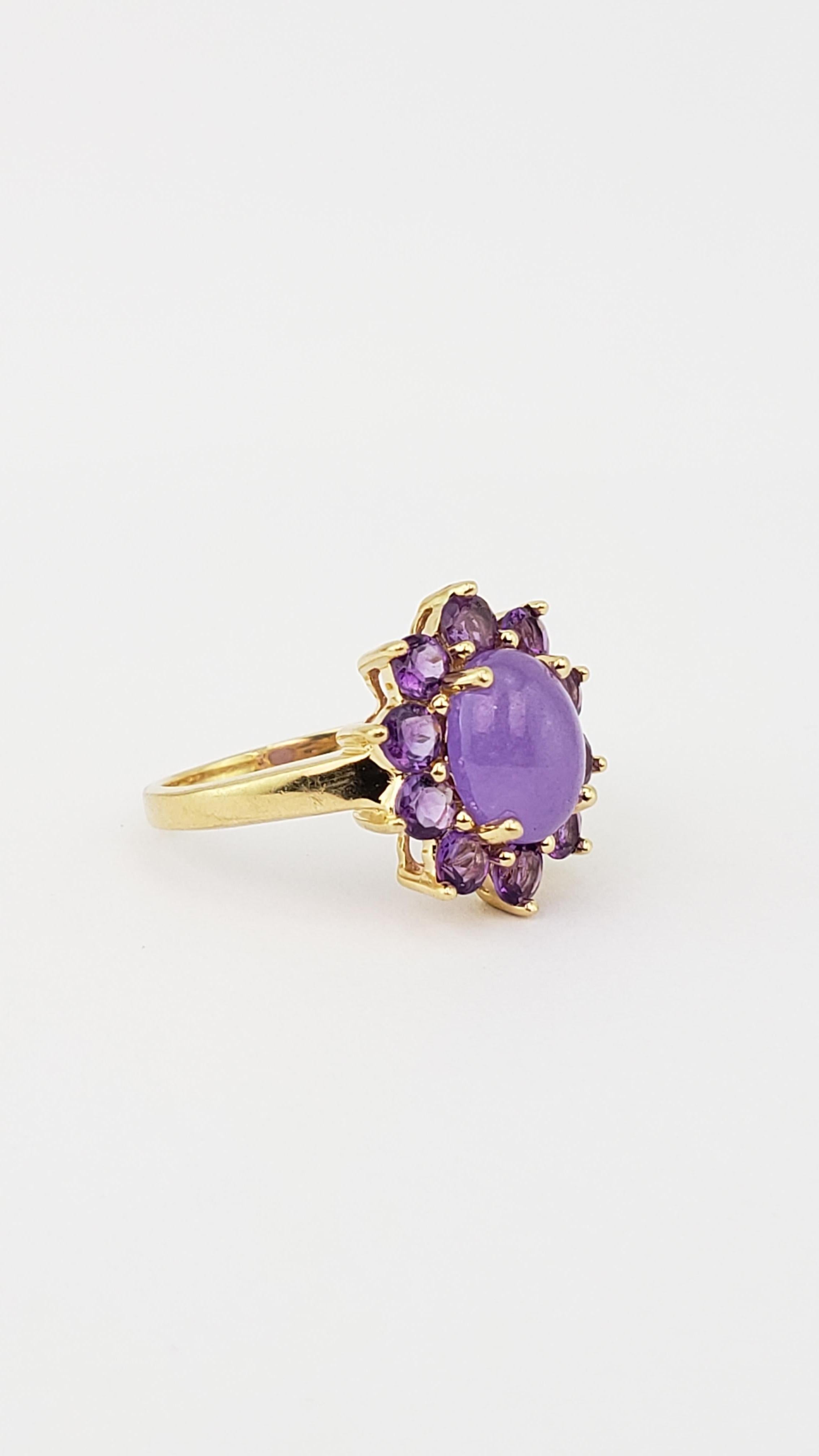 14k gold cocktail ring with lavender jade cabochon surrounded by amethysts.

Size: 6.5.

One claw set oval shape cabochon jadeite with a weight of 1.05 carats.

Ten claw set round brilliant cut natural amethysts with a weight of 0.80 carats.
