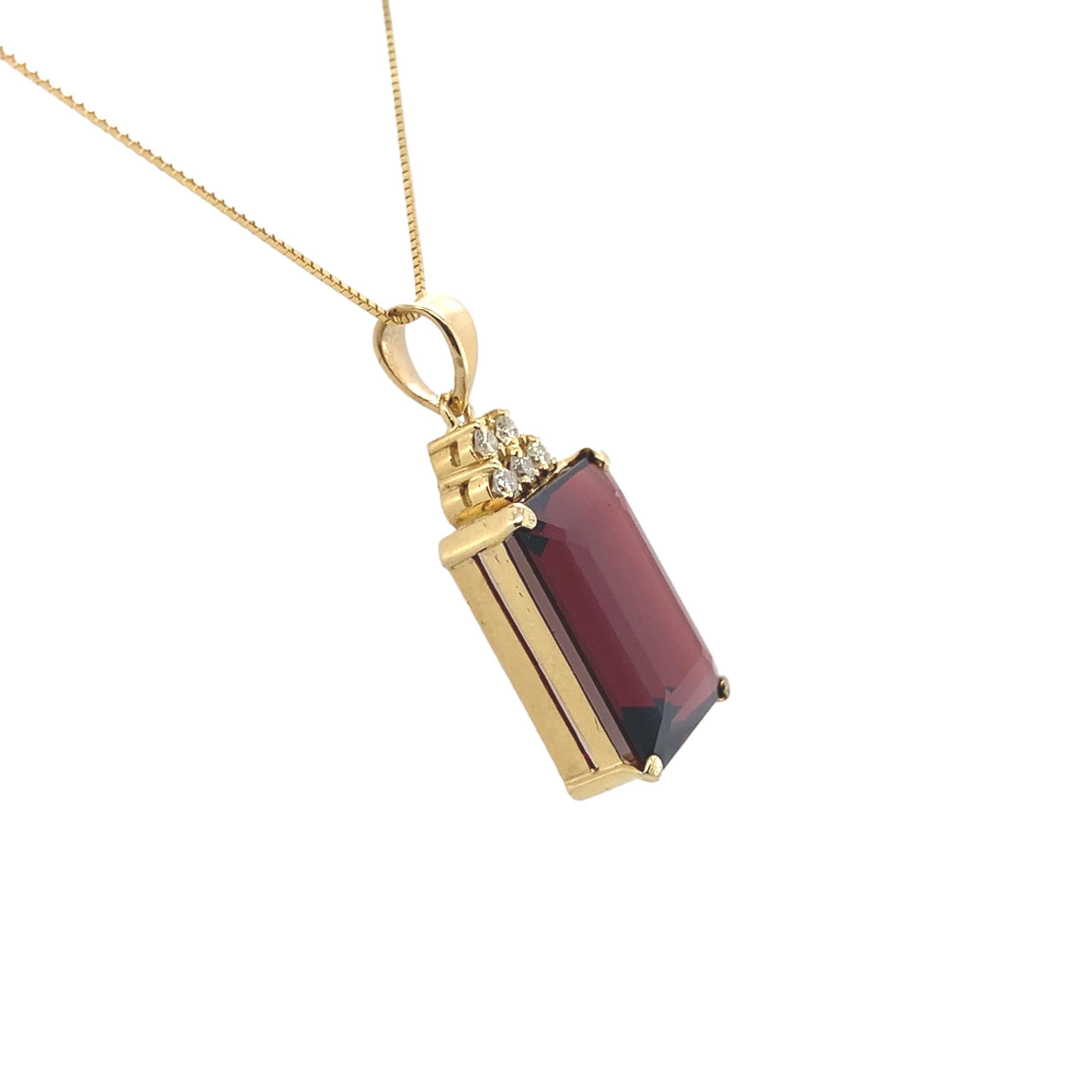 Pendentif en or jaune 14 carats, grenat et diamant, orné d'un grand grenat de terre véritable de taille émeraude. Le grenat est d'un rouge profond et mesure environ 16 mm x 12,3 mm x 6,7 mm. Son poids est estimé à 13 carats. Il y a 5 diamants ronds