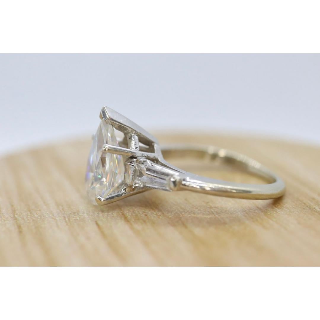 Vintage from the 1980s
Size: 5 US
Materials: Gold
Gemstone: Topaz
Gem color: Colorless

Band color: White

About this item

Beautiful 00s Solitaire Ring. Bright Colorless center White Topaz. Cut in a pear fashion. Surrounded by baguette Topaz.