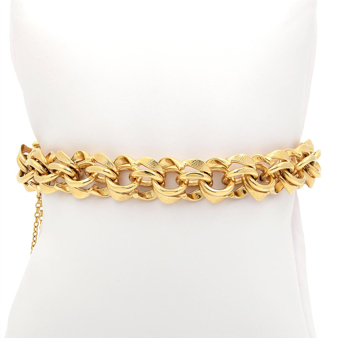This 14 karat yellow gold link charm bracelet is a uniquely crafted chain of both polished finish and Florentine textured links. The chain measures 11.25mm wide, 8 inches long, and features a safety chain. 
-	14k Yellow Gold
-	Polished & Textured