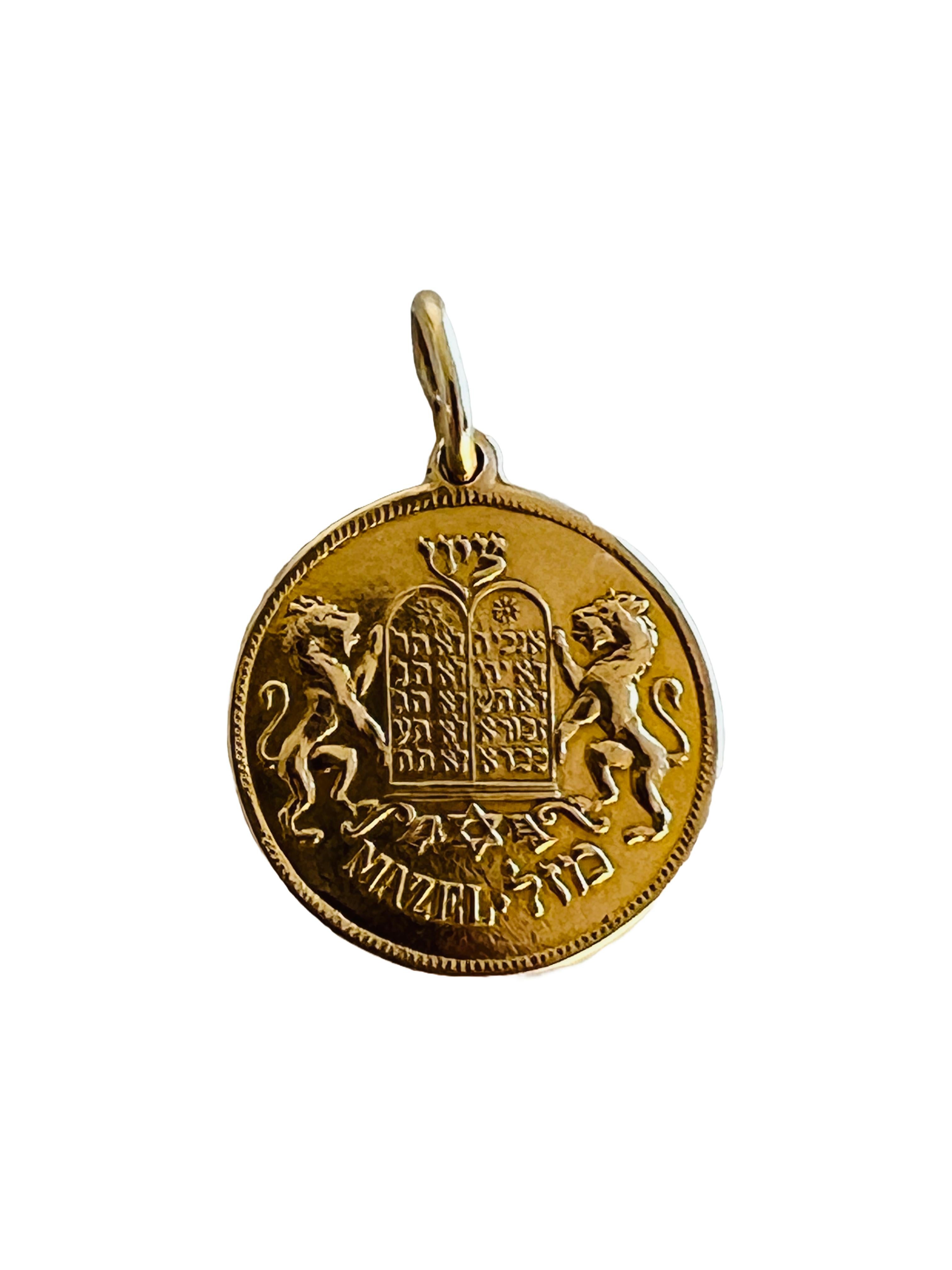 This exquisite vintage 14K yellow gold pendant (chain not included) beautifully blends Jewish symbolism and tradition, featuring the Lions of Judah flanking the Ten Commandments tablets and the Hebrew word 