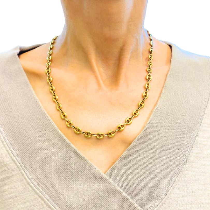 A 14k gold mariner link chain necklace. It’s a necklace with the classic mariner design: oval links with a central bar and a subtle curve that provides a nice movement and dimension. The chain hangs at just the right length for layering or styling