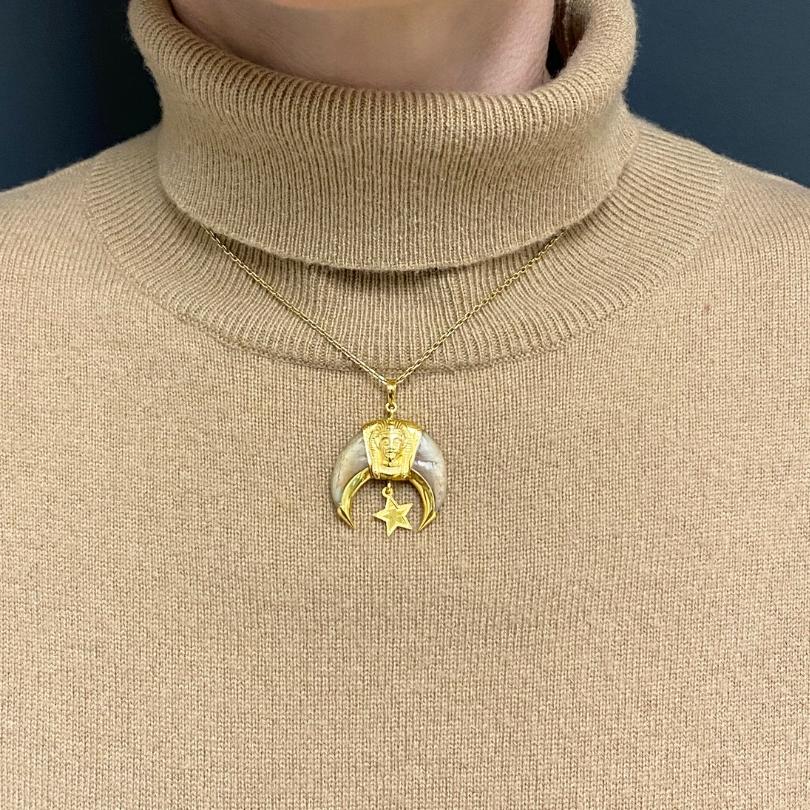 A 14k gold Masonic Knight Templar claw pendant paired with 18k gold chain.
The pendant is double sided, offering two distinct designs. On one side, a detailed regal face is framed by a headdress like border. The carved details give it a bold