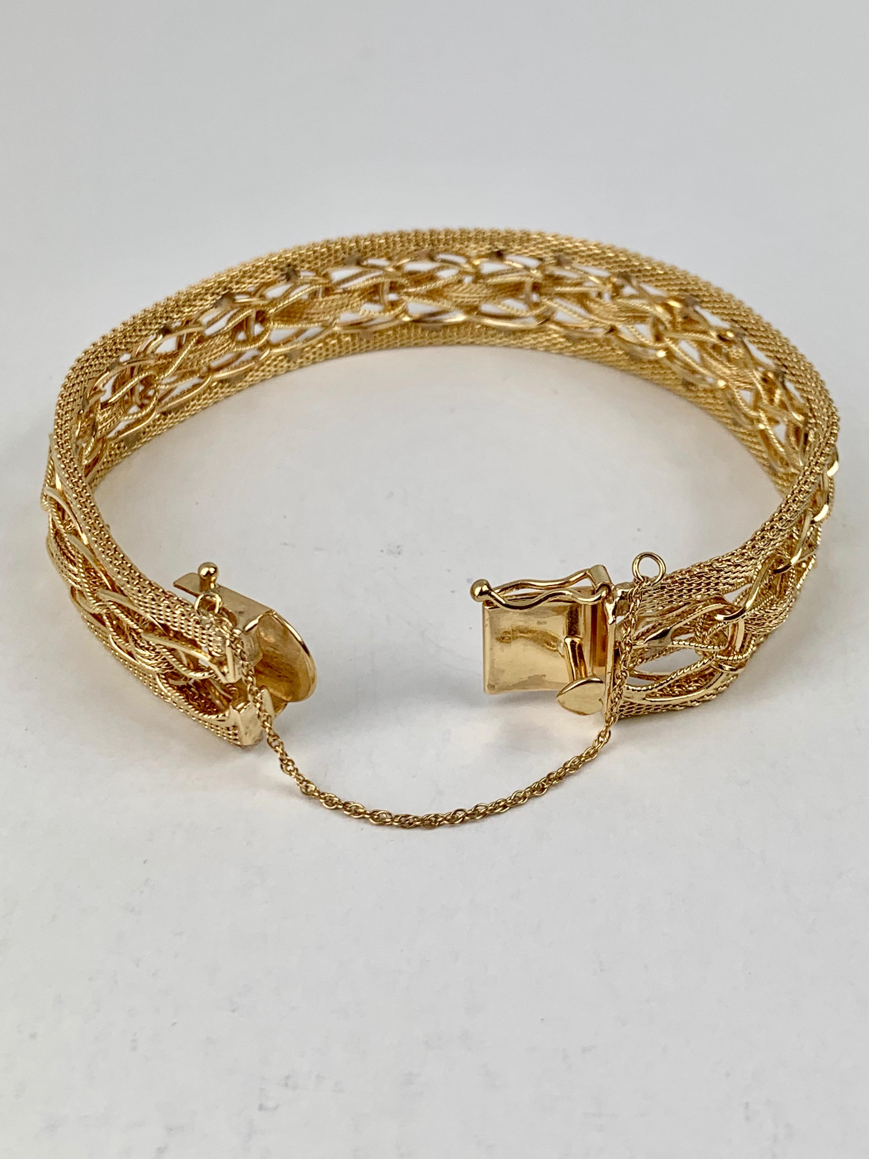 Solid 14 karat yellow gold mesh bracelet with heart shaped thumb catch plus a figure eight catch and safety chain on the side for safety. The mesh is quite interesting and partially hand woven. The bracelet is clearly marked 14k on the back of the