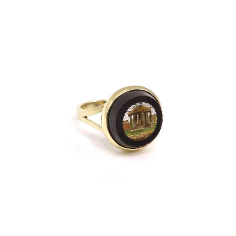 This size 6 1/2 14K ring with a split shank houses a bezel set glass and onyx micro mosaic souvenir from the Grand Tour depicting the Parthenon dedicated to the goddess Athena. The framed micro mosaic element is from the 1870’s or 80's and is in