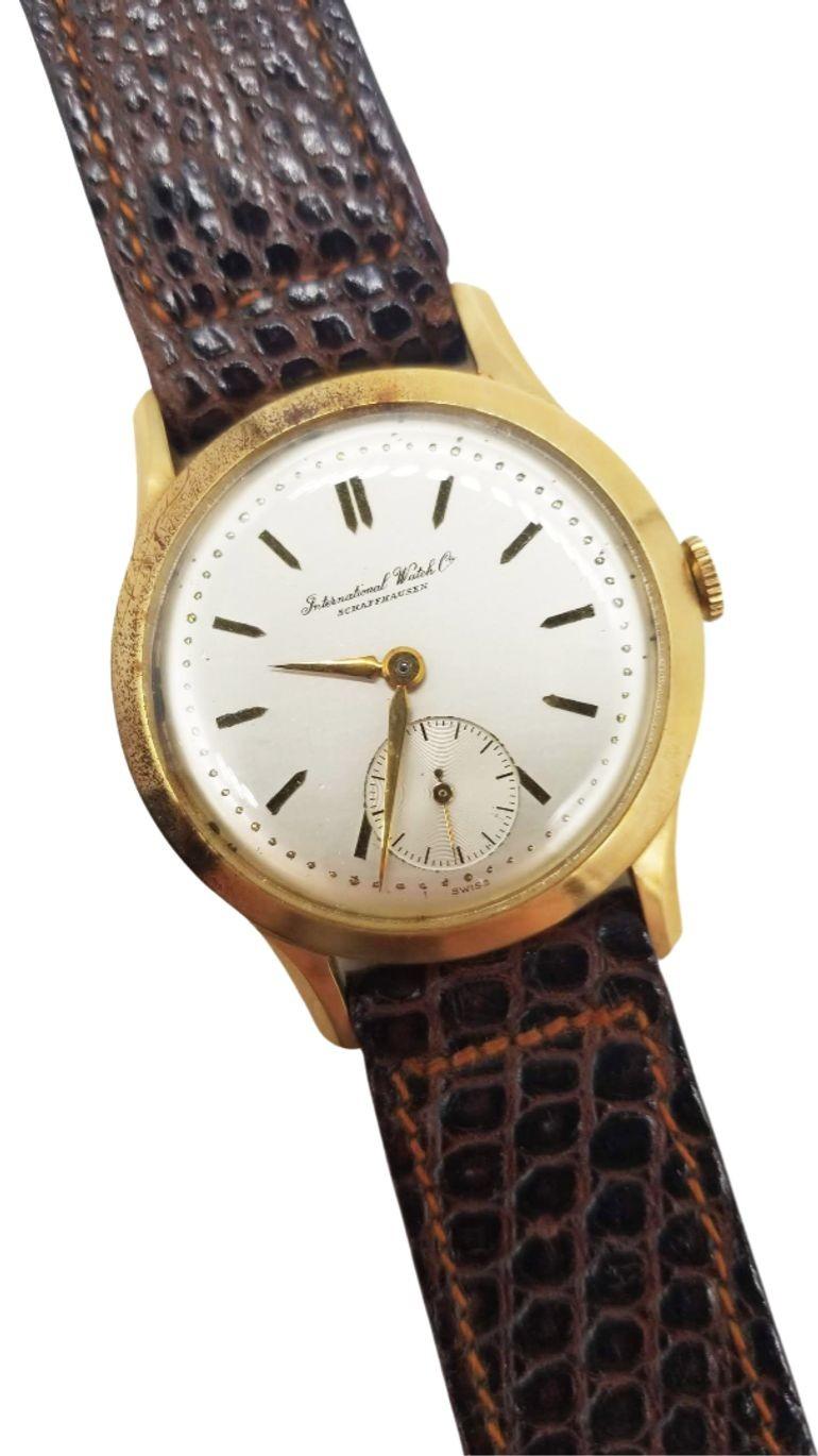 Die 14K Gold Mid Century Herrenarmbanduhr von International Watch Co. (IWC) Schaffhausen verkörpert zeitlose Eleganz. Das aus schimmerndem Gold gefertigte Design aus der Mitte des Jahrhunderts strahlt Raffinesse aus und verbindet Präzisionsmechanik