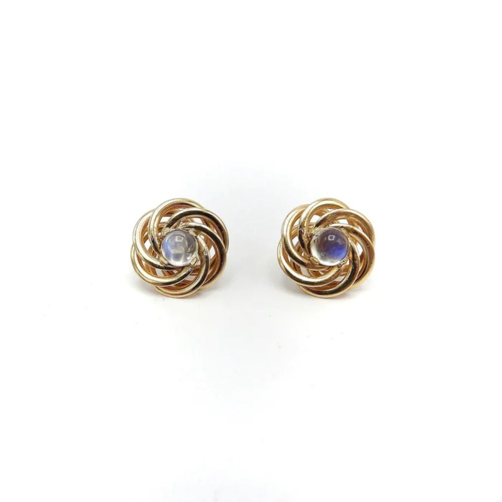 This is a classic pair of 14k yellow gold and moonstone earrings from the 1950’s. They feature a romantic love-knot made with gold swirls that surround each luminous moonstone. They are prong set stud earrings with a 5.5 mm deep cabochon moonstone
