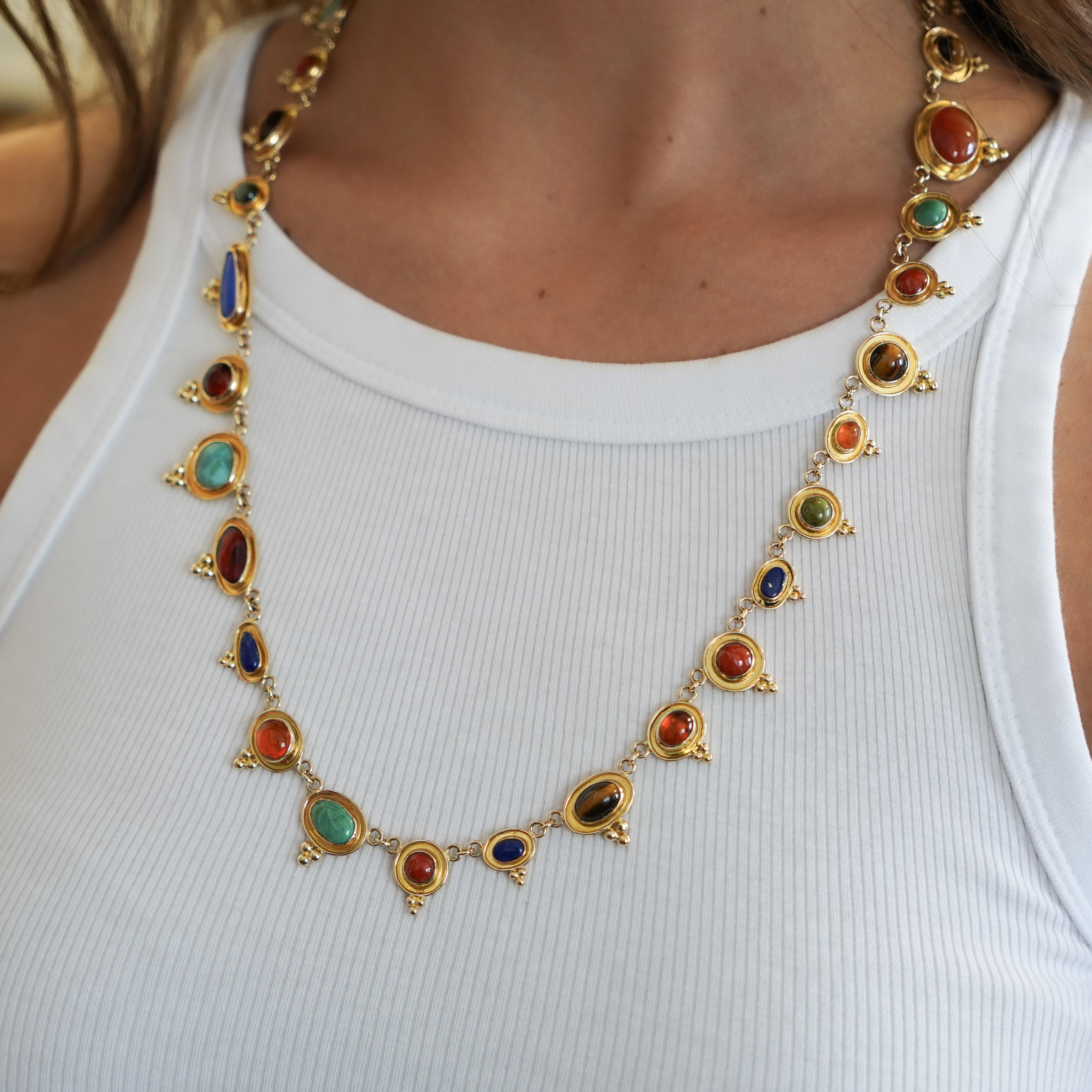 This exquisite 14K yellow gold necklace features a collection of different gemstones, all with unique colors, hues, and effect. Including cats-eye, lapis lazuli, tiger's-eye, amber, turquoise, and topaz. The 24-inch length gives the necklace a