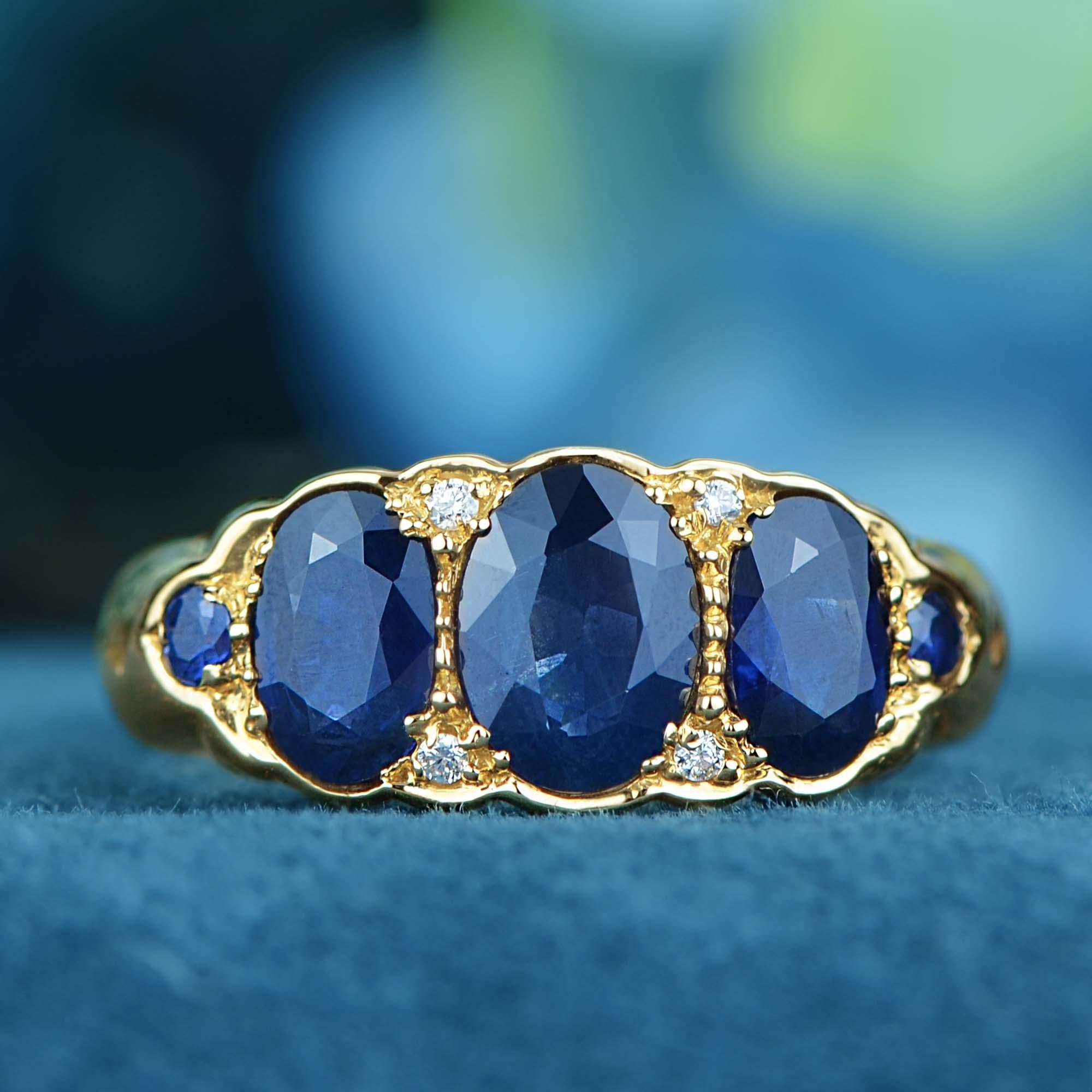  A stunning three-stone ring showcases three oval natural blue sapphires set side by side, radiating deep, vibrant color. Between each sapphire, sparkling diamonds are delicately placed, adding brilliance and enhancing the overall design. The