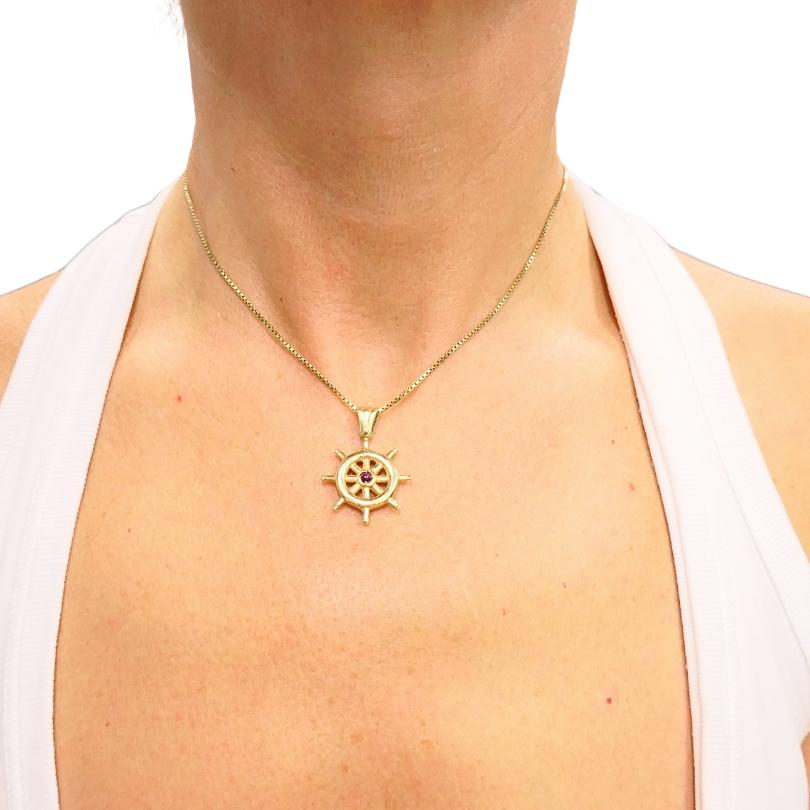 Fabriqué en or 14k, cet élégant collier est orné d'un pendentif en forme de roue de bateau finement détaillée, symbolisant l'orientation et l'aventure. Le centre est orné d'un diamant, ajoutant un éclat raffiné au motif maritime. Le pendentif est