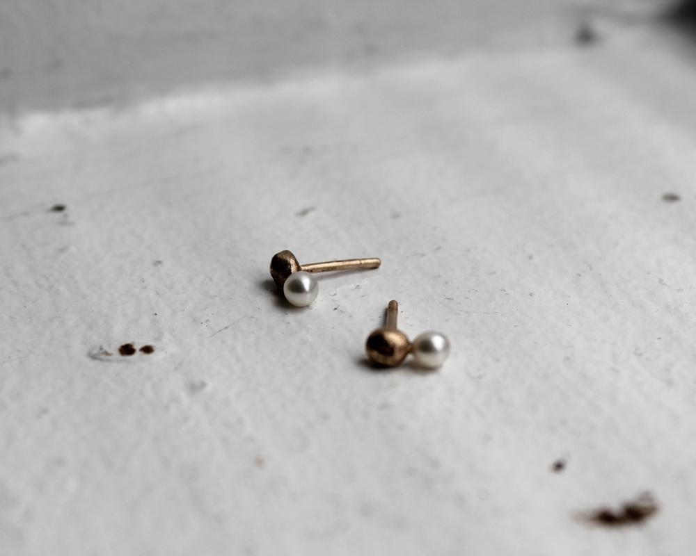 These made-to-order 14k gold earring studs feature 14k gold nugget spheres with freshwater pearls. Paying homage to tradition, each earring is formed from scratch using heirloom tools from Franny's Father and Grandfather. The organic signature