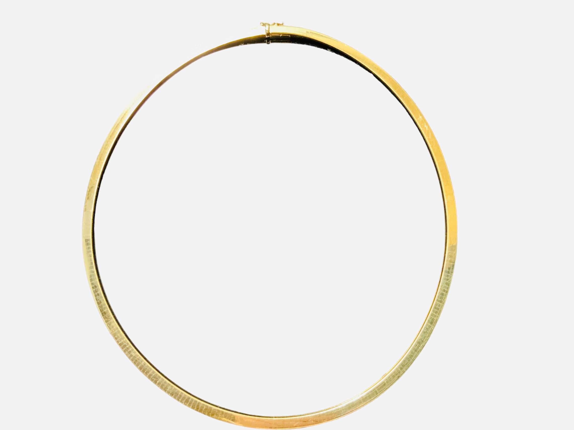 This is a 14K gold Omega link necklace. The necklace’s length is 17.75 inches and width is 4mm. It has a hidden box clasp with an eight safety lock. Its weight is 27.0 grams.