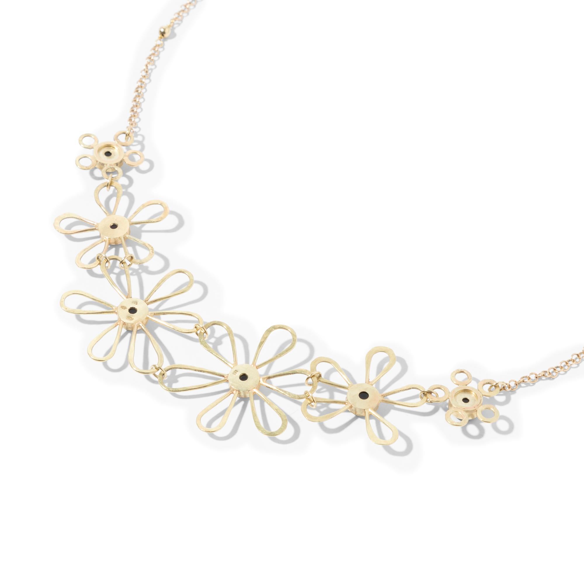Playful and light. This handcrafted 14k gold necklace sits comfortably around the neck like a garland of daisies. The six flowers are assembled to allow maximum movement and the hearts consist of doublet opals. An extra eye at the end of the chain