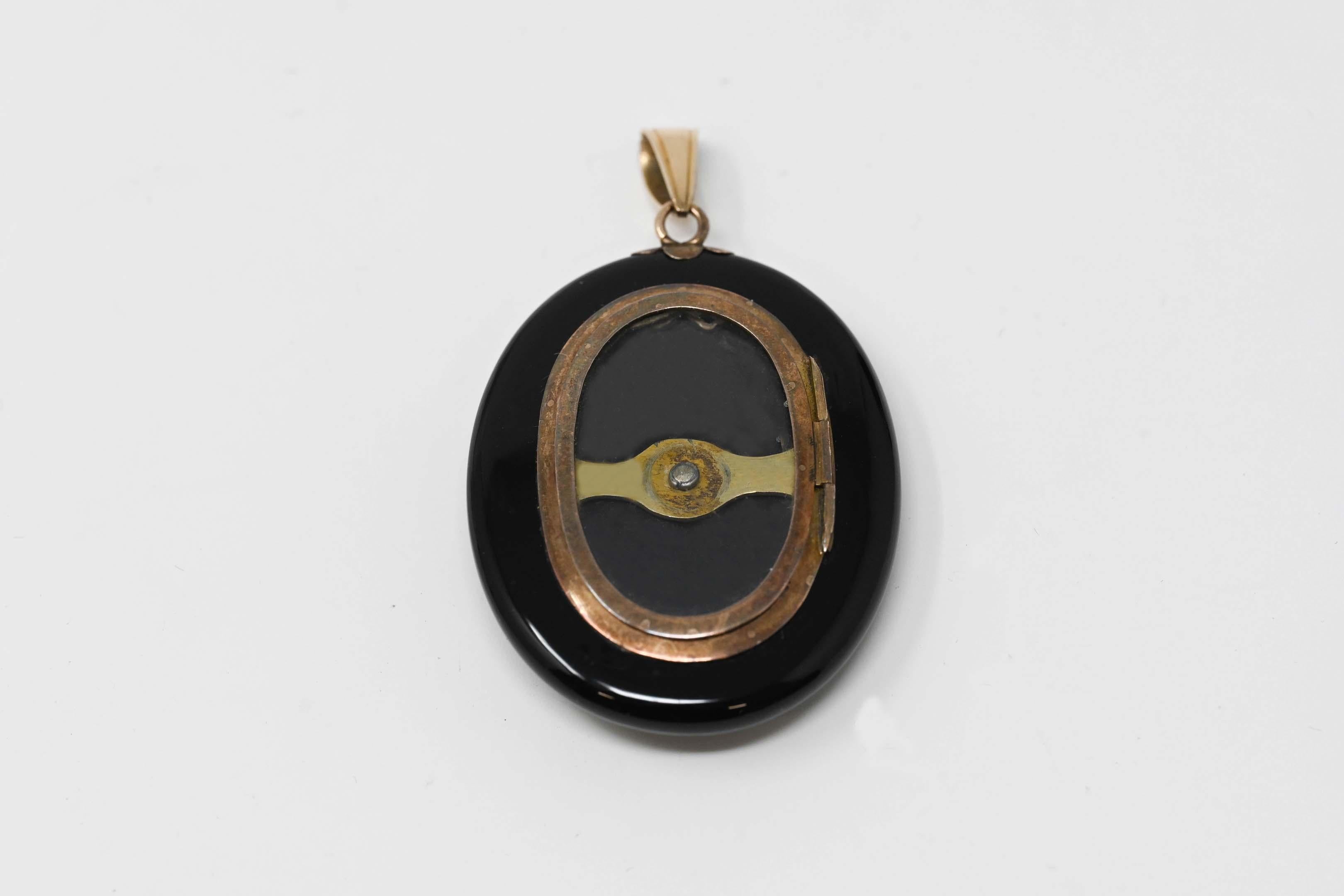 14k yellow gold and one piece onyx mourning locket pendant with 10 rosette cut diamonds on the back. Measures 2 inches x 1 5/8 inches without a loupe. In excellent condition.