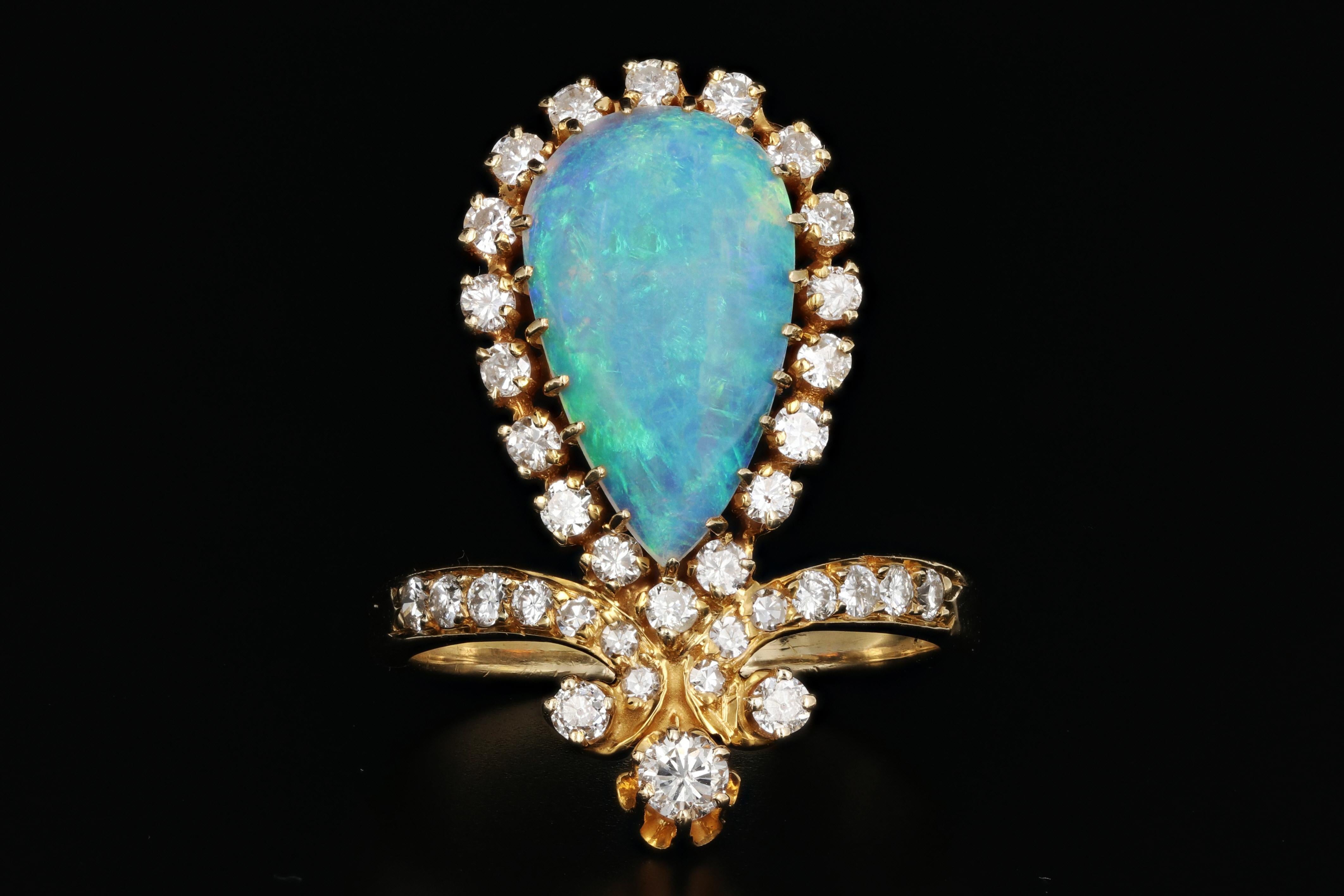 Hallmarks: 14K

Composition: 14k Yellow Gold

Primary Stone: Opal

Stone Carat: approximately 4 carats

Shape: Pear

Accent Stone: Diamonds

Color/Clarity: G/H - Vs2/Si1

Total Diamond Weight: .75 carats

Ring Width: 1.1