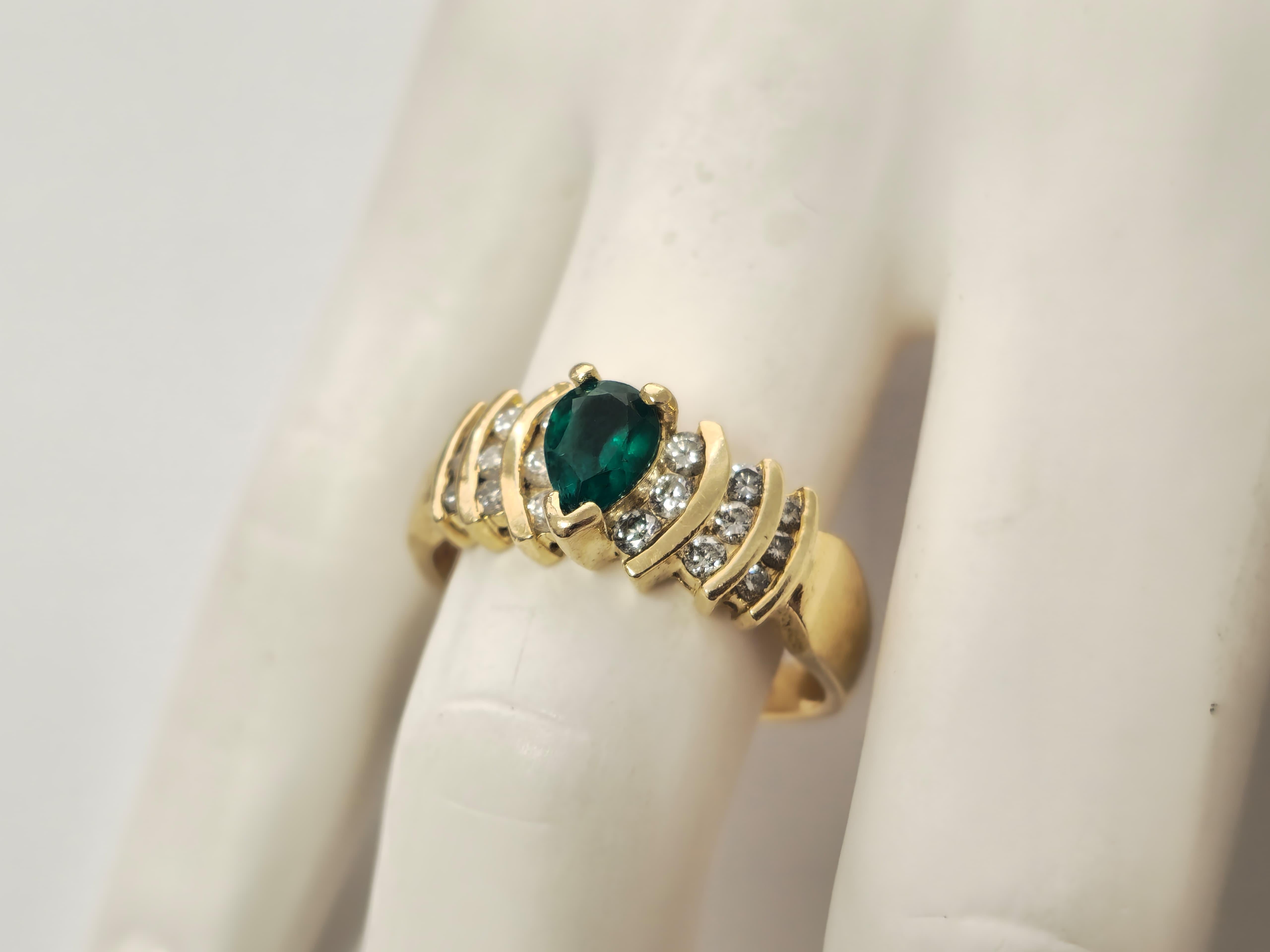 Indulge in elegance with this 14k yellow gold ring. Featuring a captivating 1-carat pear-shaped emerald complemented by 1.87 carats of round diamonds with VS2 clarity and G color, this piece offers sophistication. Ideal for ring resizing, weighing