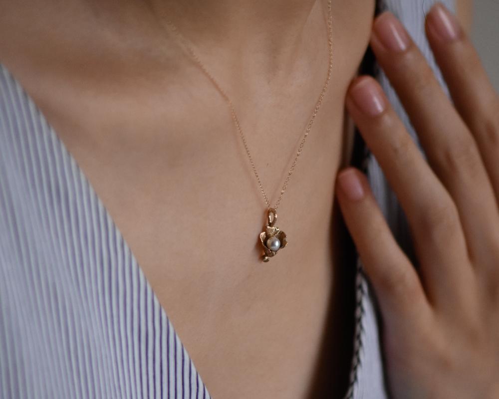 This made-to-order necklace features a hand-fabricated 14k gold lily with a budding freshwater pearl. Much like the florals that inspire them, each lily is unique and showcases signature textures, making each piece one-of-a-kind. Paying homage to