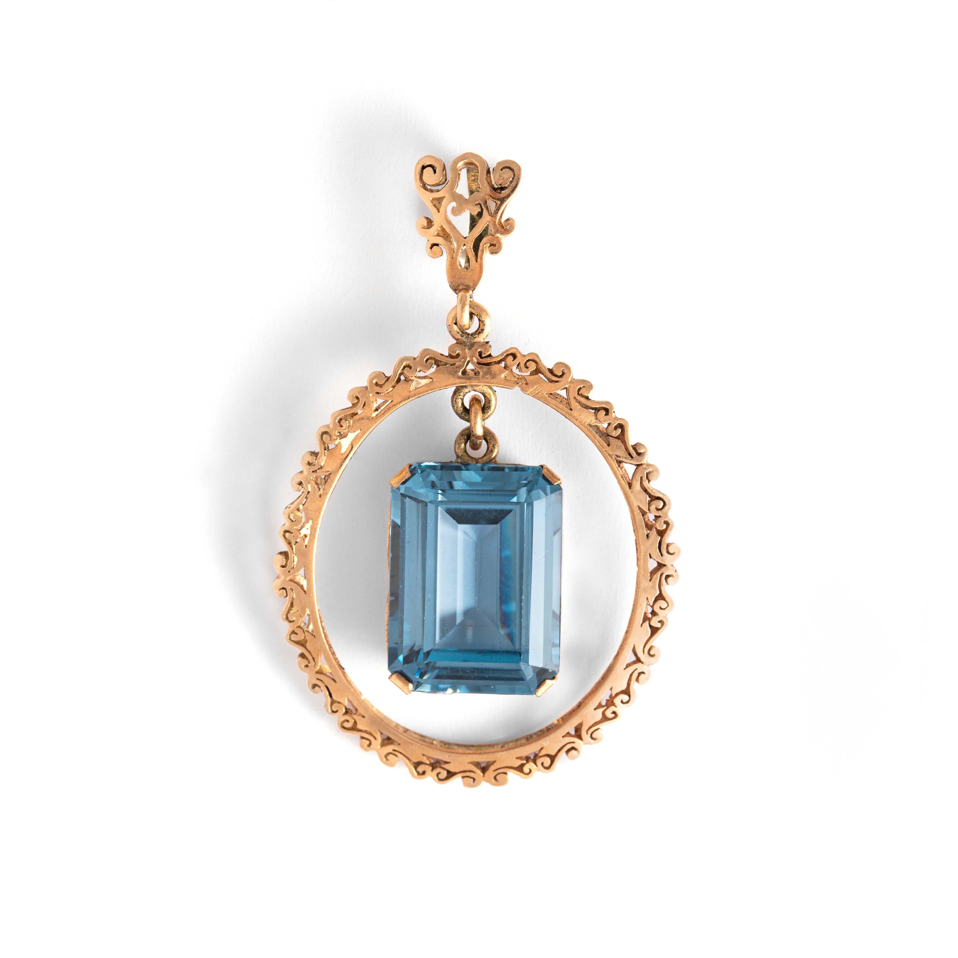 14K gold pendant holding a large emerald-cut blue stone.
Dimensions: 5.70 centimeters x 3.50 centimeters. 
Gross weight: 13.03 grams.