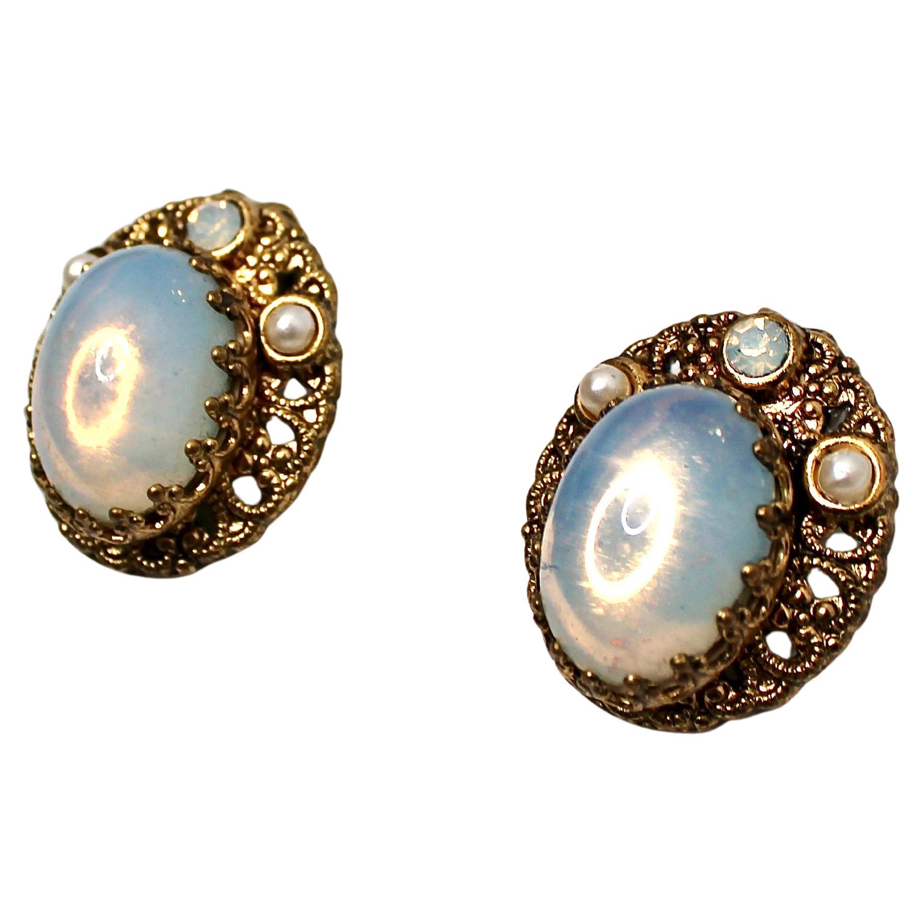 Questi raffinati orecchini a clip degli anni '70 presentano un delicato e intricato design in filigrana, splendidamente realizzato in Germania Ovest con placcatura in oro 14k che emana eleganza vintage. Il centrotavola è caratterizzato da opali