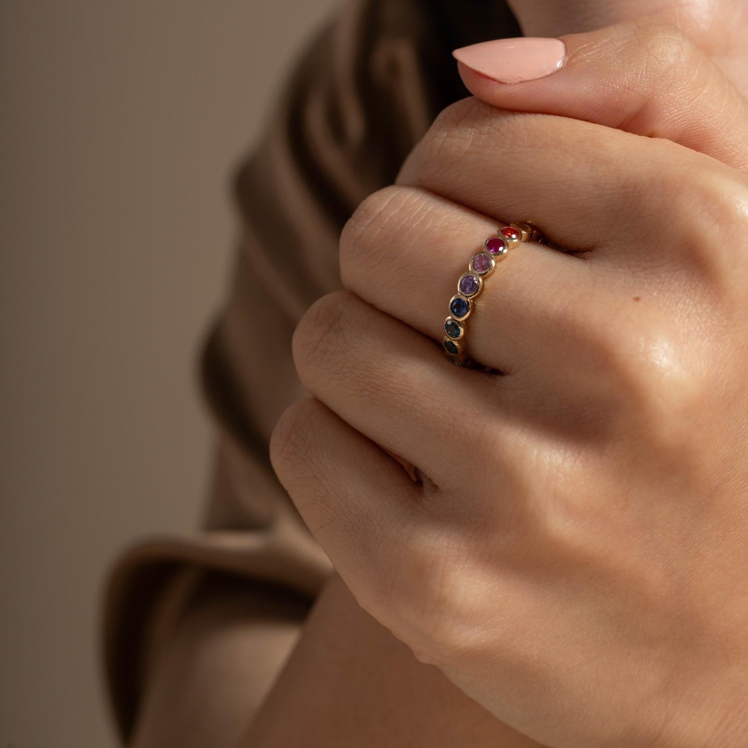 Handcrafted in our London studio, this 14k yellow gold eternity style ring is adorned with a rainbow selection of sapphires around half of the band. The modern molecular design makes this sparkling ring a contemporary classic that is perfect for