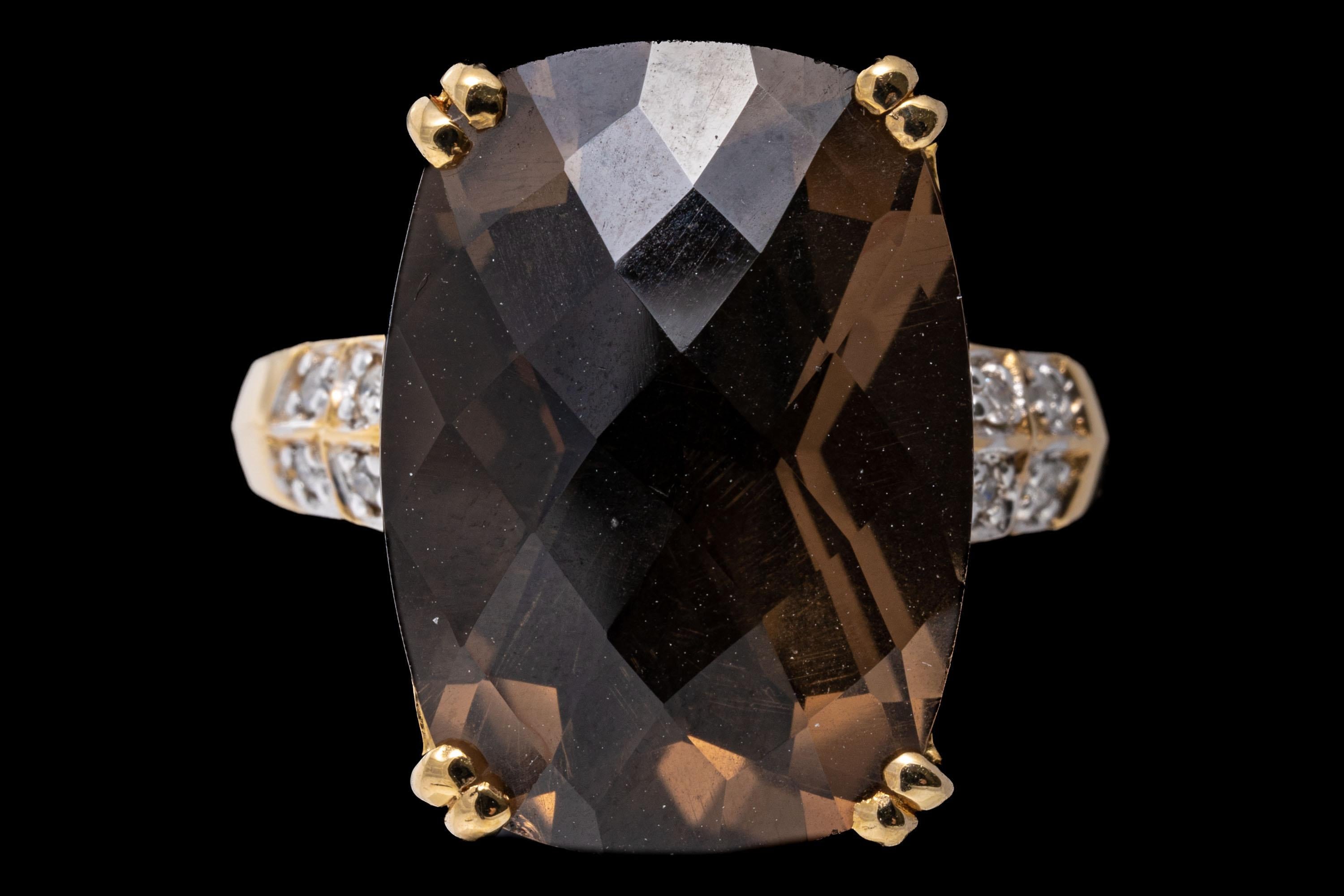 14k yellow gold ring. This pretty ring features a rectangular checkerboard cushion, dark brown color smoky quartz center, approximately 11.61 CTS, set with split prongs and flanked by round faceted accent diamonds, approximately 0.04 TCW. The ring