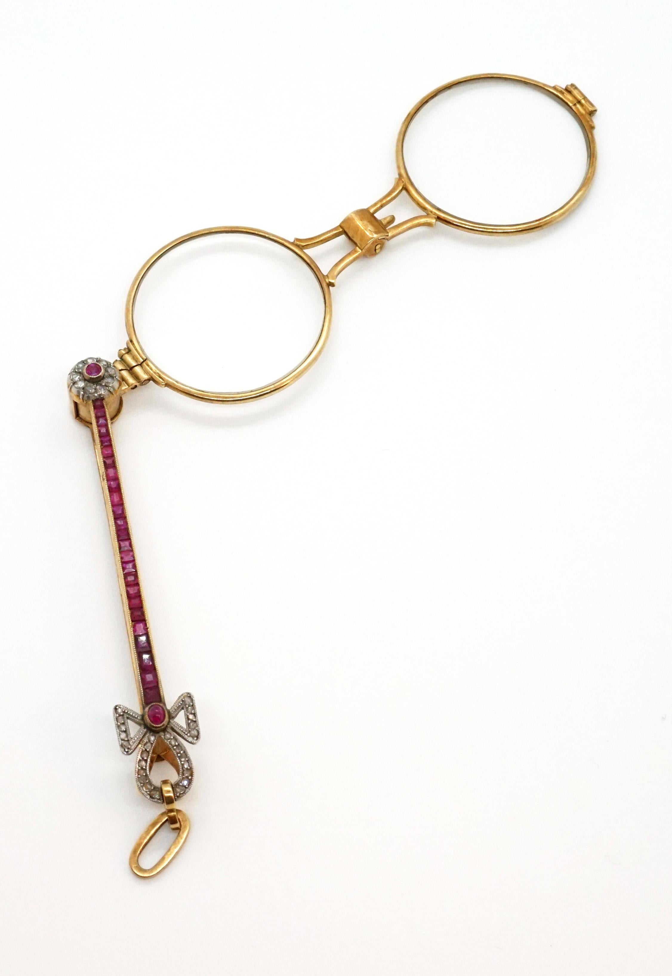 Elegant Antique Lady's Lorgnette 14k/585 Gold With Red Ruby Stones. The foldable frame can be turned into the handle which is equipped with sqare ruby stones. The ends of the handle, of which one is shaped as a ribbon, are set with numerous old cut
