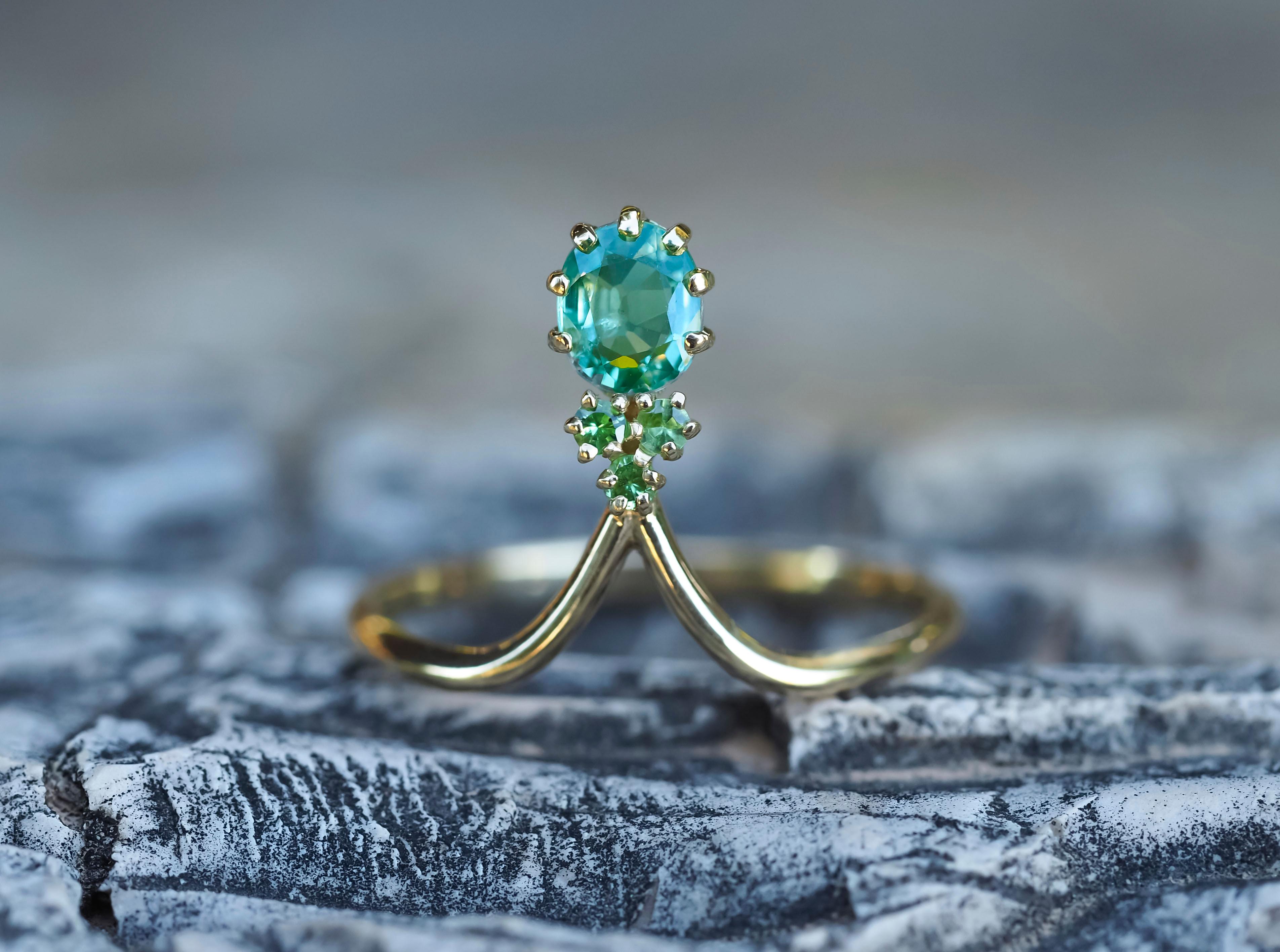 14k gold ring with sapphire and tsavorites

Metal: 14k solid gold
Total weight 1.8 gr

Sapphire
Oval cut, 0.8 ct, transparent, bluish green color. 
Tsavorites (green garnet)
Round cut, transparent, green color., 3x0.05 =0.15 ct 

auct