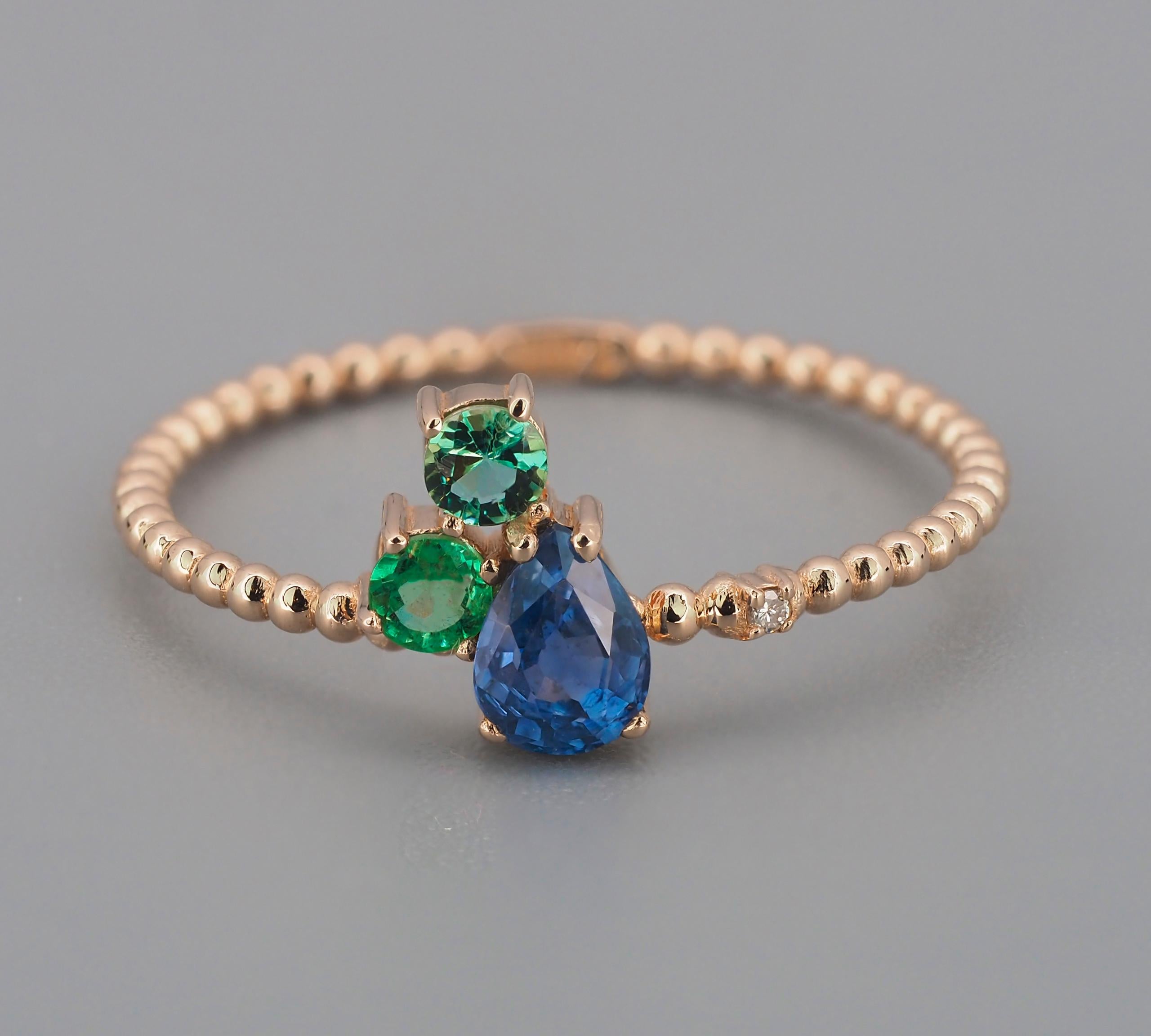 14 kt solid gold ring with natural sapphire, emeralds and diamond. September birthstone.

Weight: 1.3 g.

Gemstone: 
Natural  sapphire:
Weight - approx 0.50 ct, cut - pear
Color - blue, clarity - transparent with inclusions (See in photo)
Natural