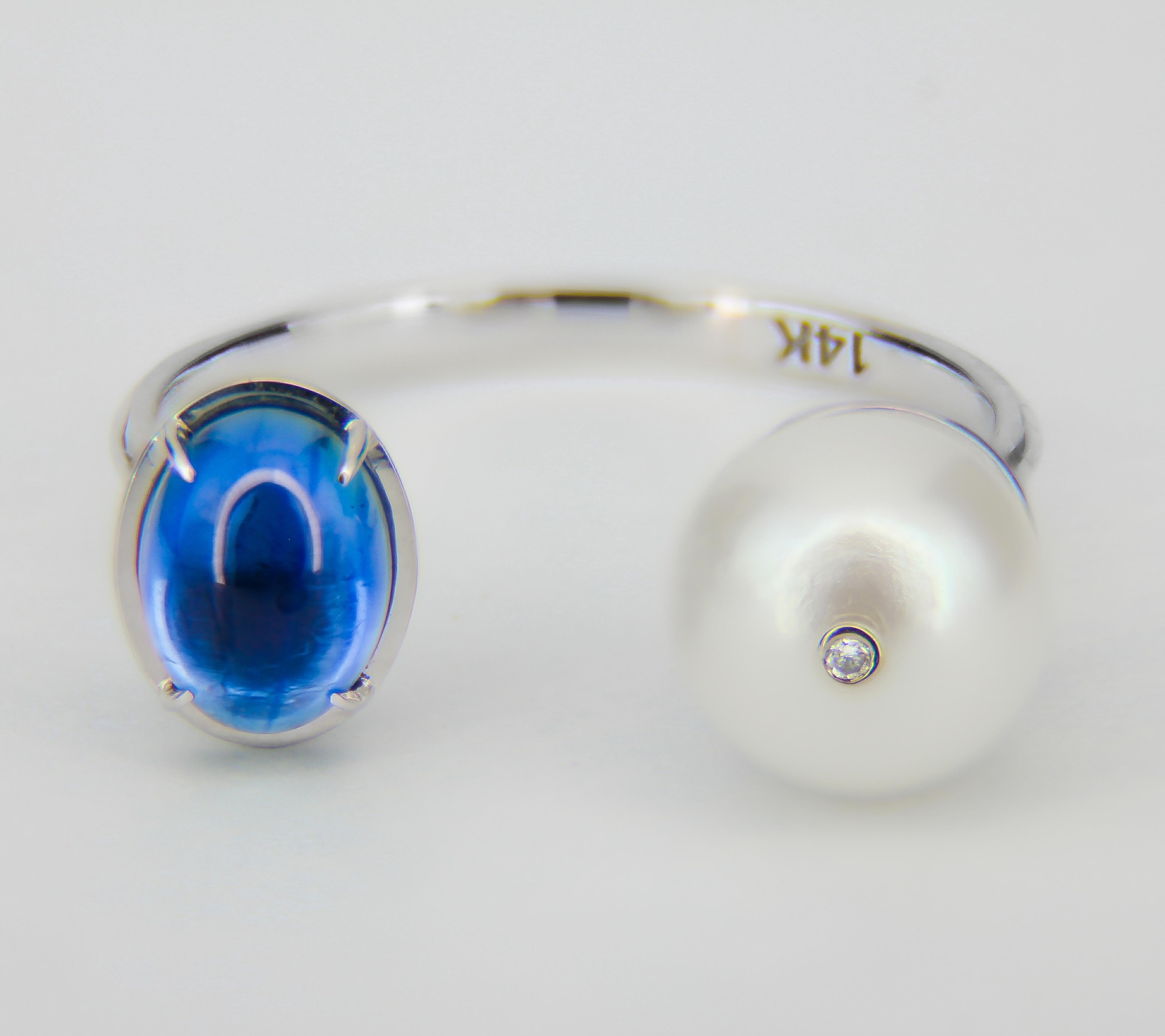 14k gold ring with sapphire, pearl and diamond. September birthstone.
Weight: 2.50 g.

Central stones: Natural sapphire
Weight - approx 1.00 ct in total, color - blue, oval cabochon cut.
Clarity: Transparent with inclusions
Side stones:
Pearl: 6.5