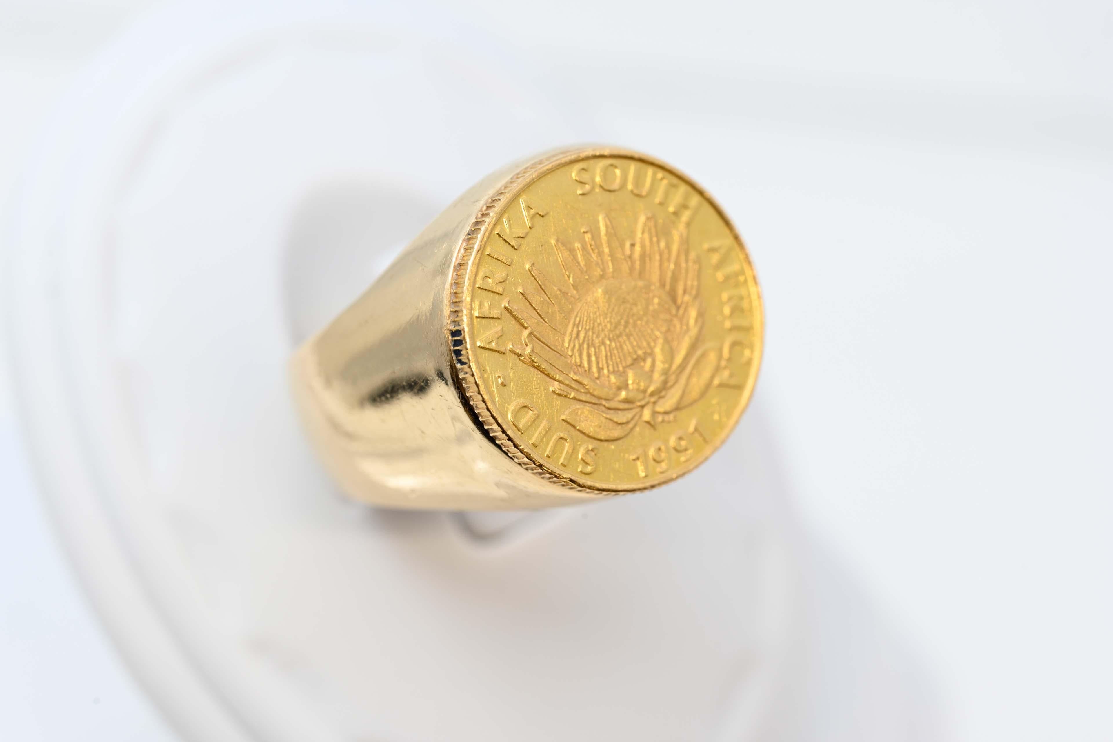 Bague en or 14k avec pièce d'or d'Afrique du Sud 1891-1991 1/10 oz d'or fin Verpleging Protean Nursing, diamètre de la pièce 16.5mm. Bague de taille 7 3/4, fin du 20e siècle. Afrique du Sud, poids total 13,4 grammes. En bon état.