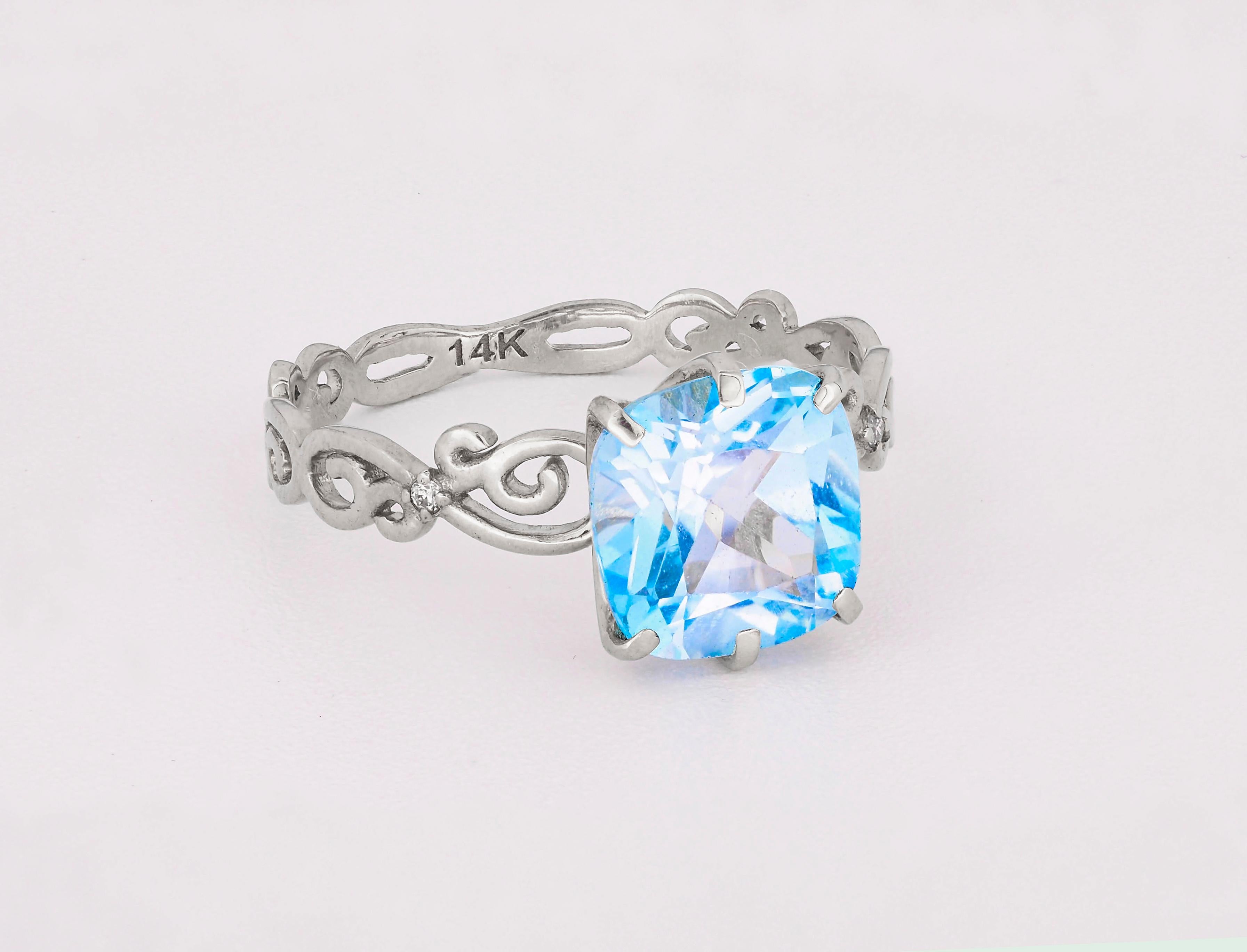 14 k solid gold ring with natural topaz and diamonds. November birthstone.
Weight: 2.00 g.

Central stone: Natural topaz
Cushion cut, weight - approx 3.00 ct. in total, color - blue
Clarity: Transparent with inclusions
Surrounding stones: 
Diamonds:
