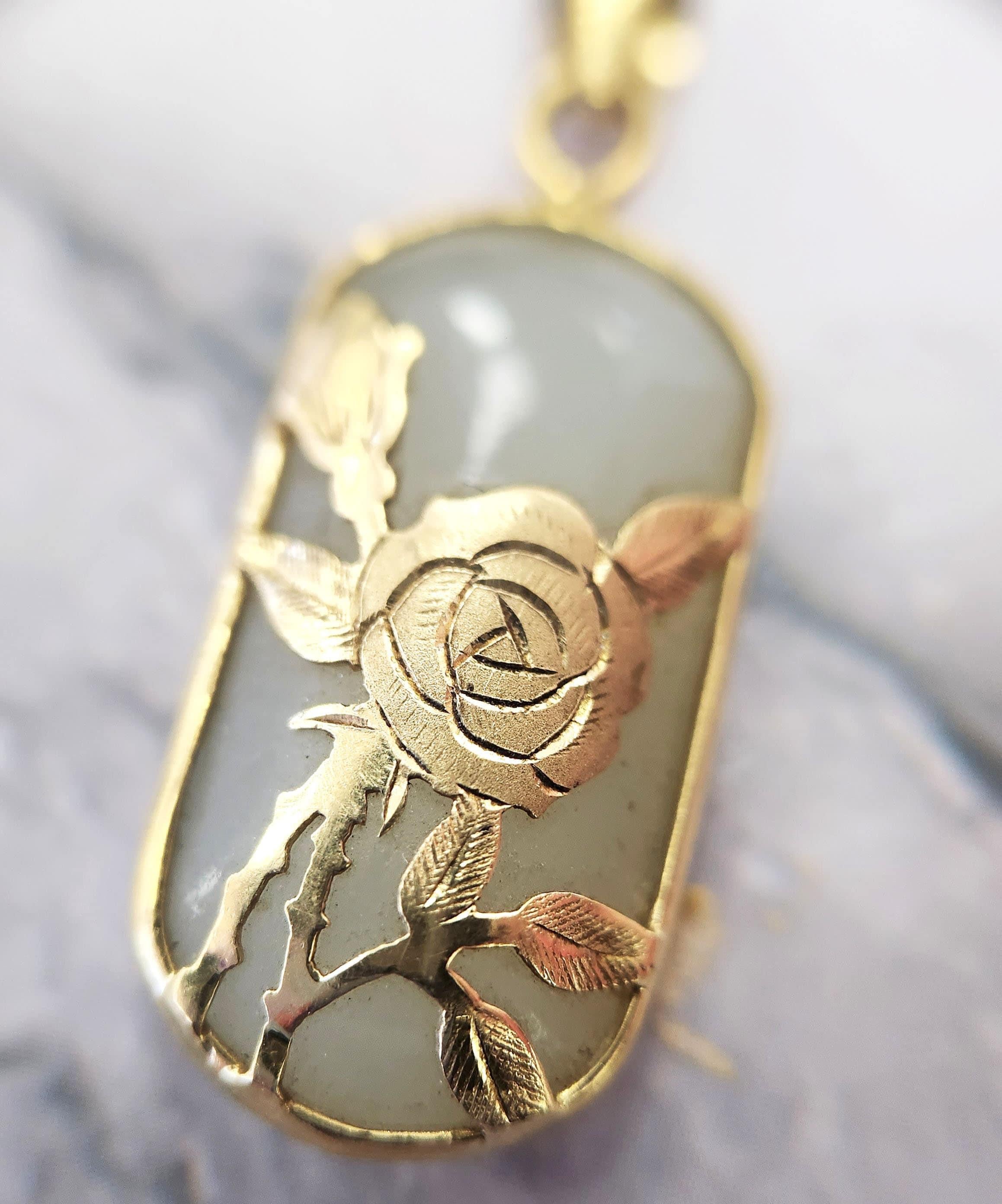Bezel set hand engraved rose overlaying a natural smooth nephrite gemstone

Nephrite is a gemstone that belongs to the jade family.
It is valued for its beautiful deep green color and smooth texture.

1cm x 2.5cm

This bale will fit most chains.