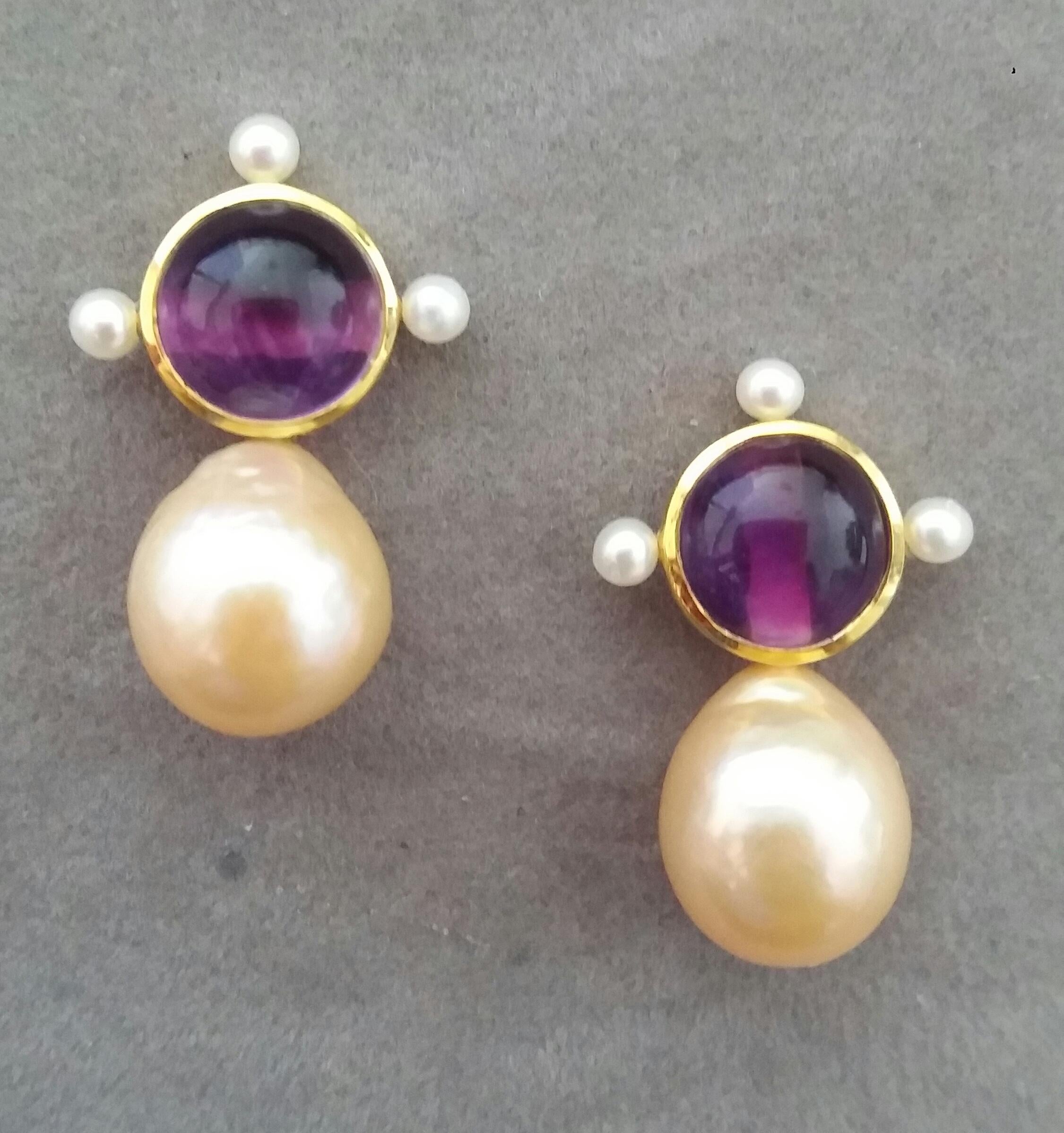 These elegant and handmade earrings have 2 Natural Amethyst round cabs measuring 10 mm in diameter set in a 14 Kt yellow gold bezel with 3 small white round pearls of 3 mm on 3 sides at the top to which are suspended 2 Natural Golden Color Pear